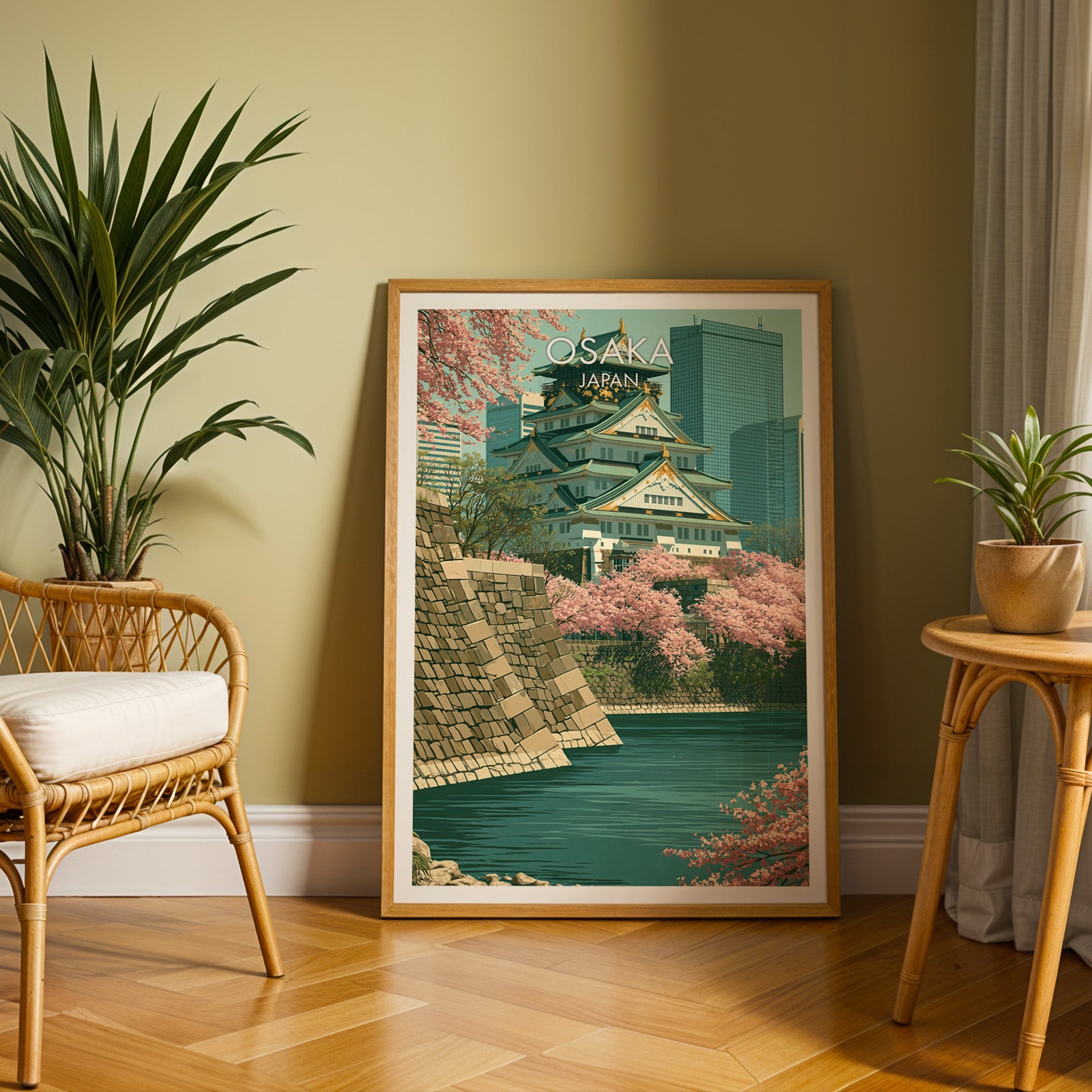 Large Osaka Castle Japan travel print in an oak frame leaning on a herringbone floor next to a rattan chair