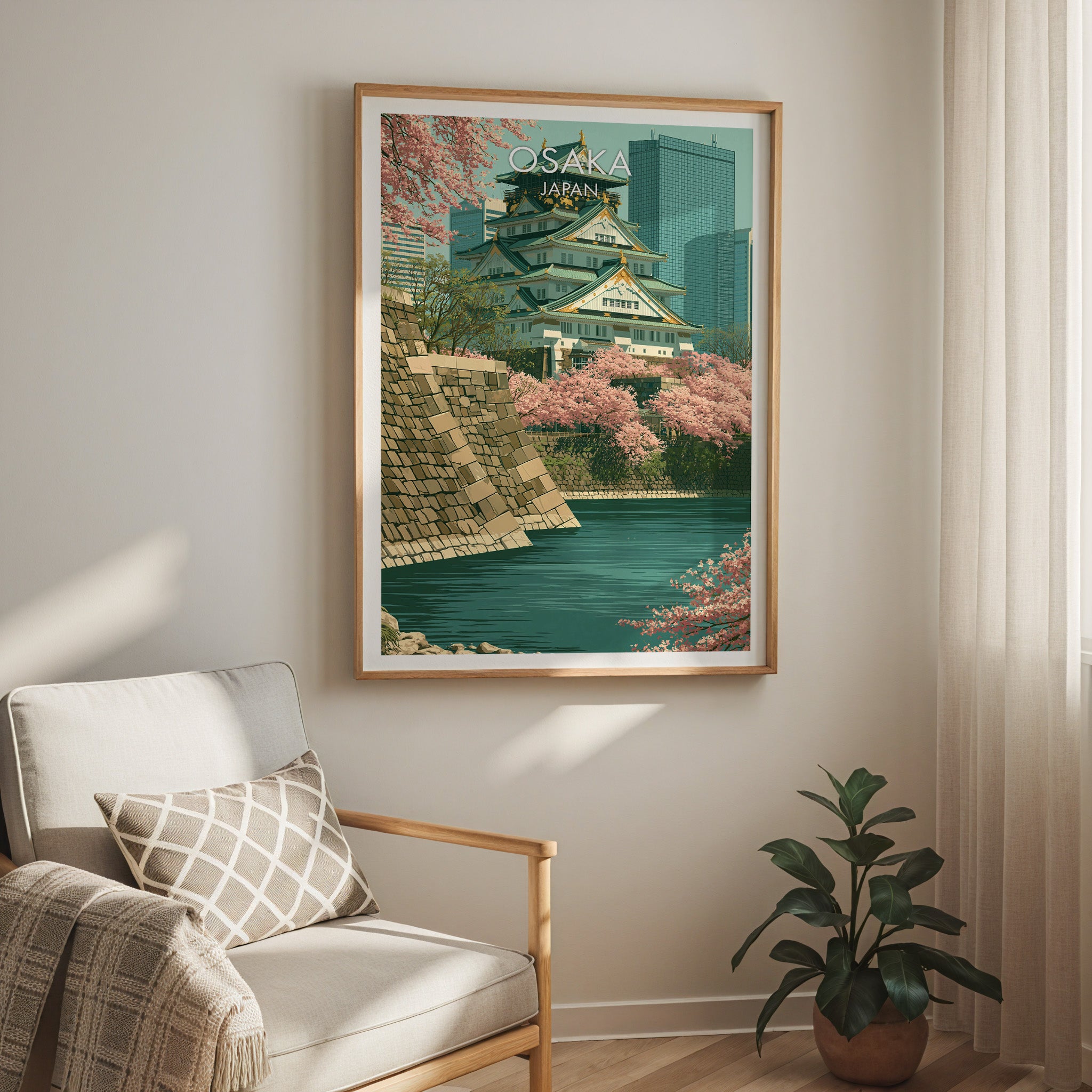 Osaka Castle Japan travel print in a light oak frame on a living room wall beside a linen armchair