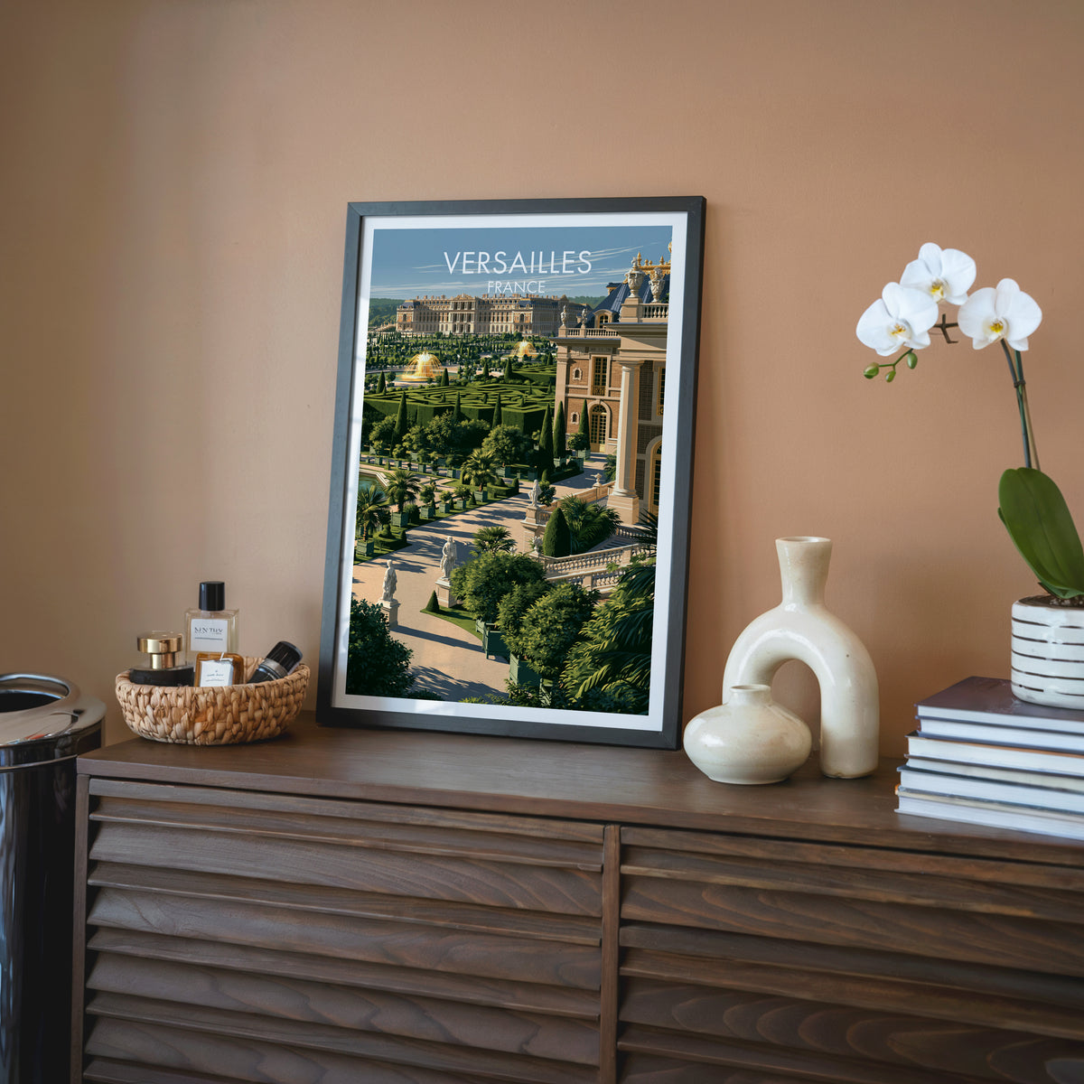 Versailles France wall art, black frame on a walnut sideboard against a terracotta wall with a white orchid