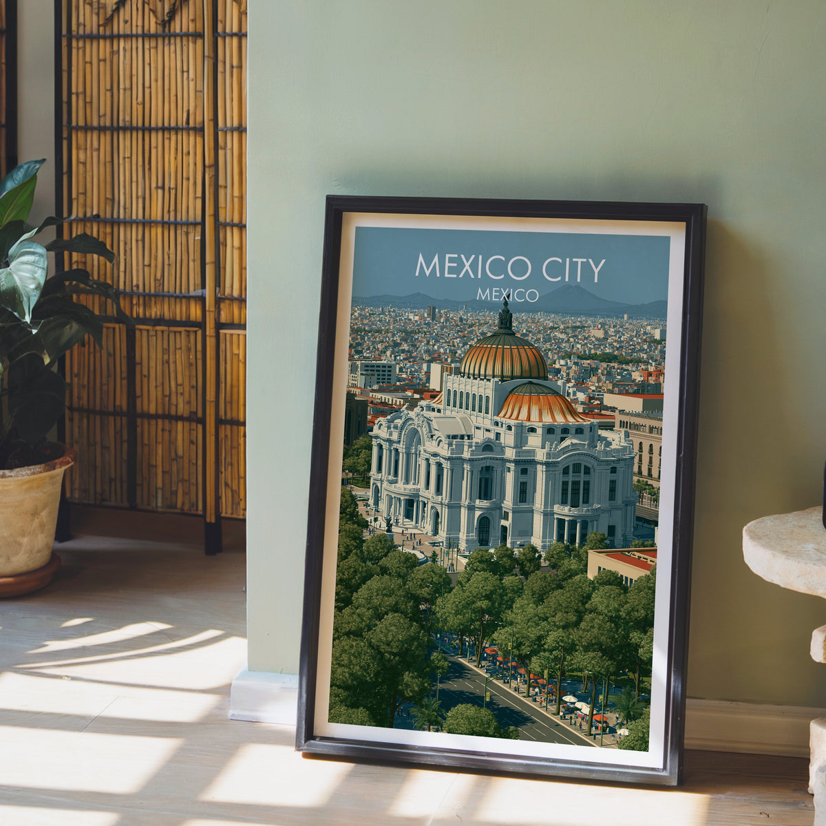 Amber and orange domes print, black frame leaning on pale wood floor by a sage-green wall and bamboo screen