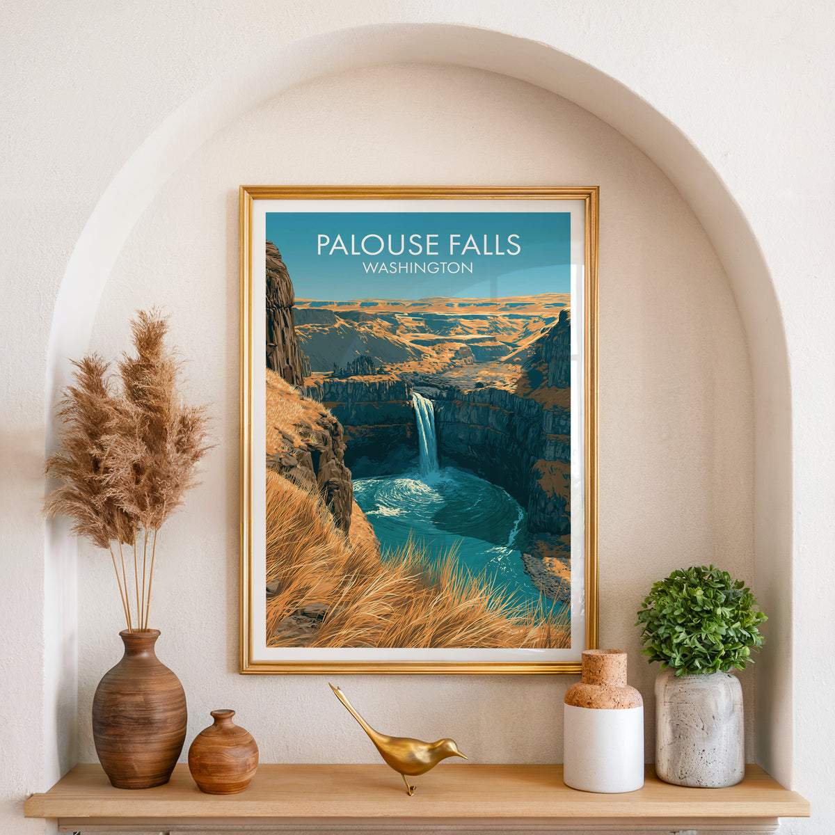 Palouse Falls Washington art in a gold frame set in an arched wall niche with pampas grass and a brass bird