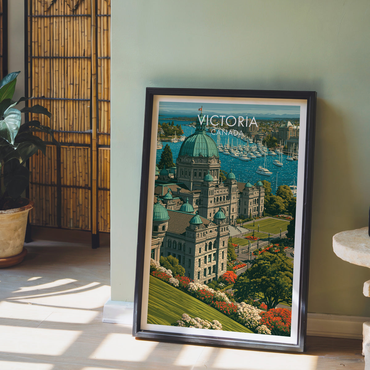 BC Parliament travel print in a black frame on the floor by a sage wall and bamboo screen