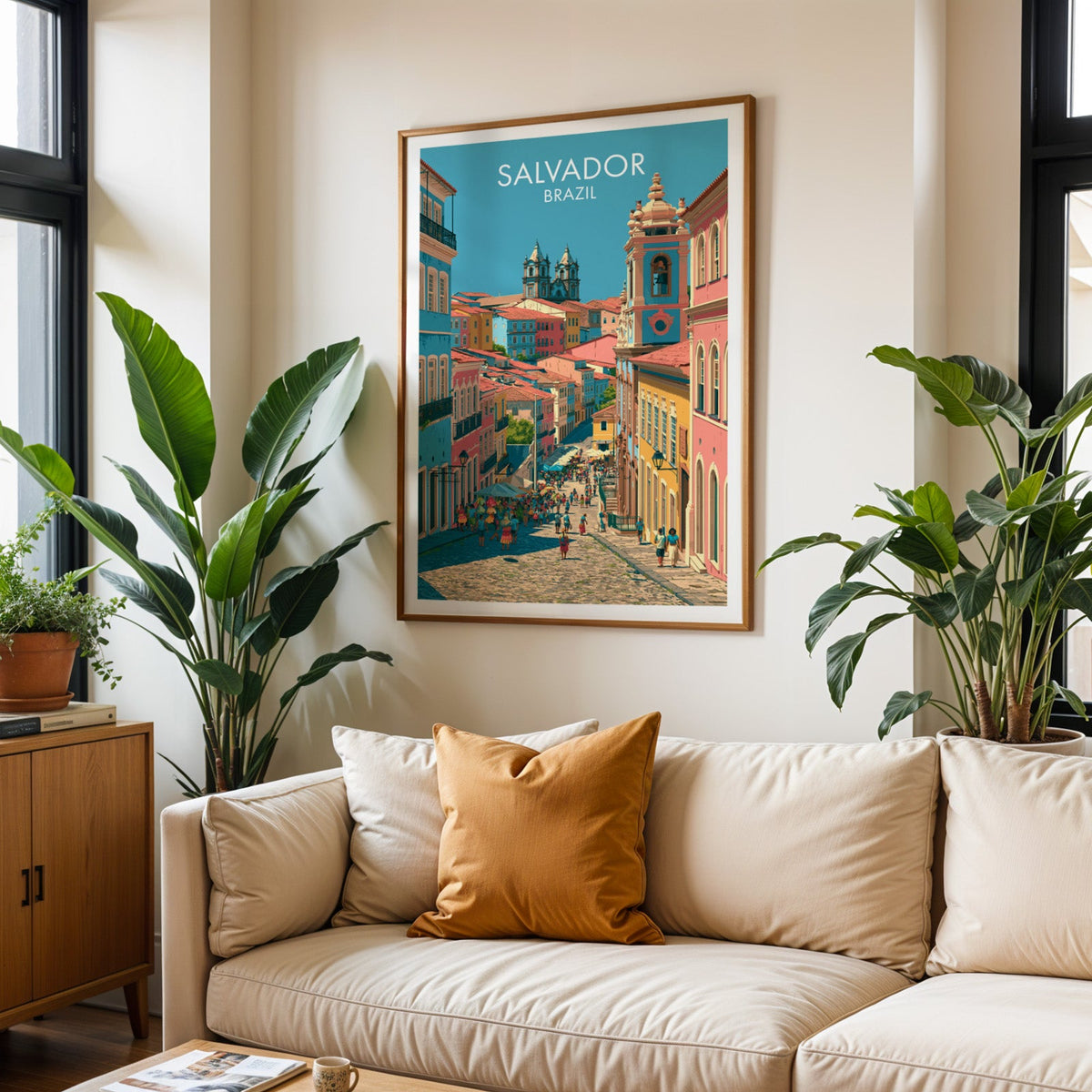 Pelourinho street poster in an oak frame above a cream sofa with rust cushions, tropical plants and a black window