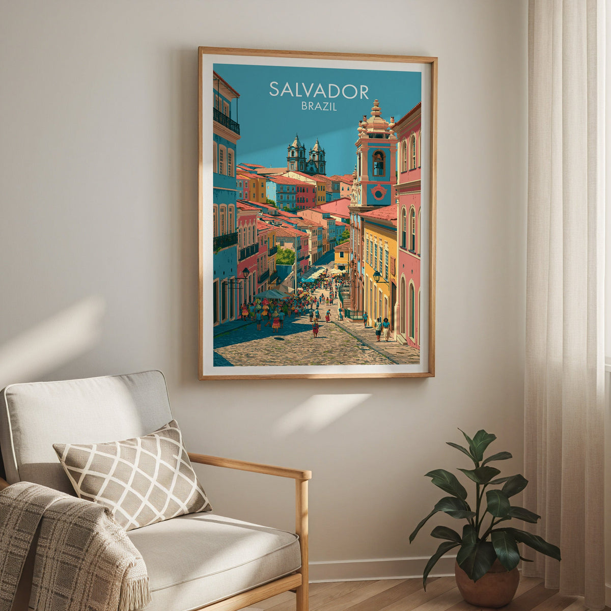 Pastel Bahia street print in an oak frame above a cream armchair with a checked cushion and a rubber plant