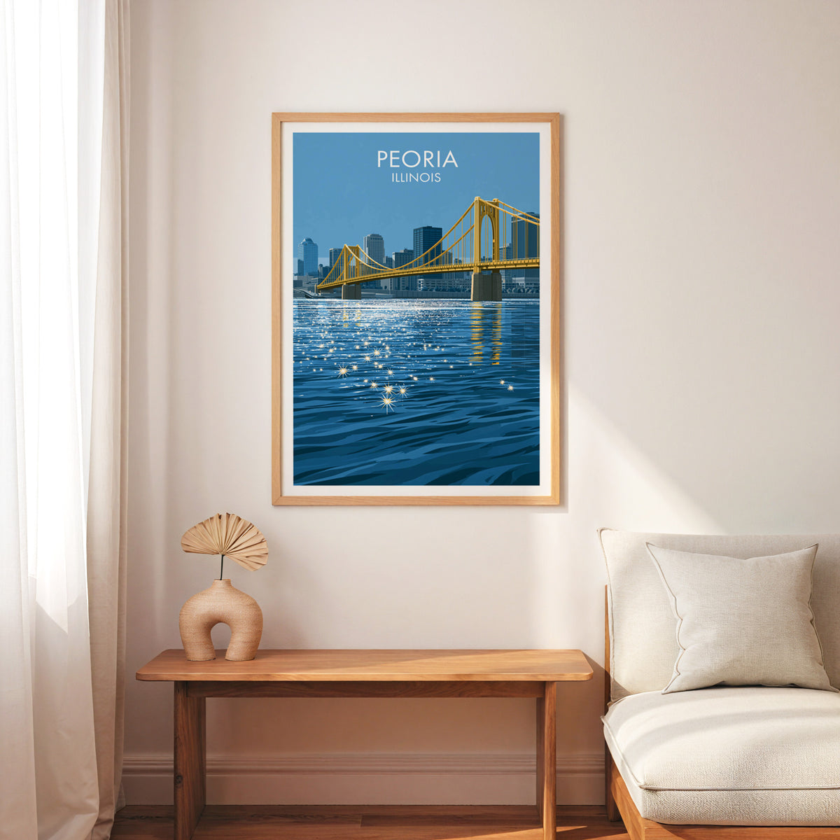 Suspension bridge poster in an oak frame on a white wall over a slim bench, cream armchair and palm fan