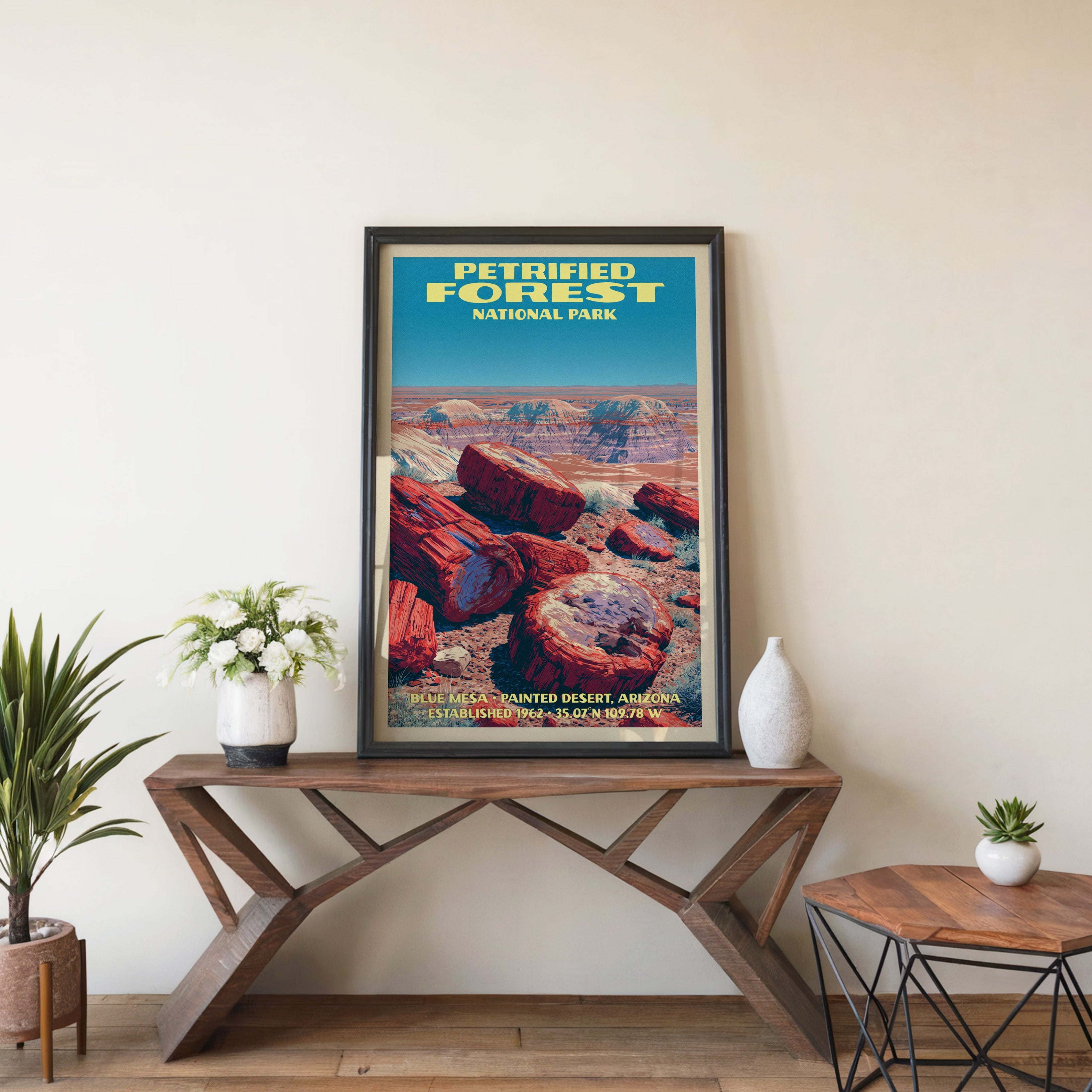 Petrified Forest Blue Mesa wall art in black, leaning on a walnut console with white anemones and a vase
