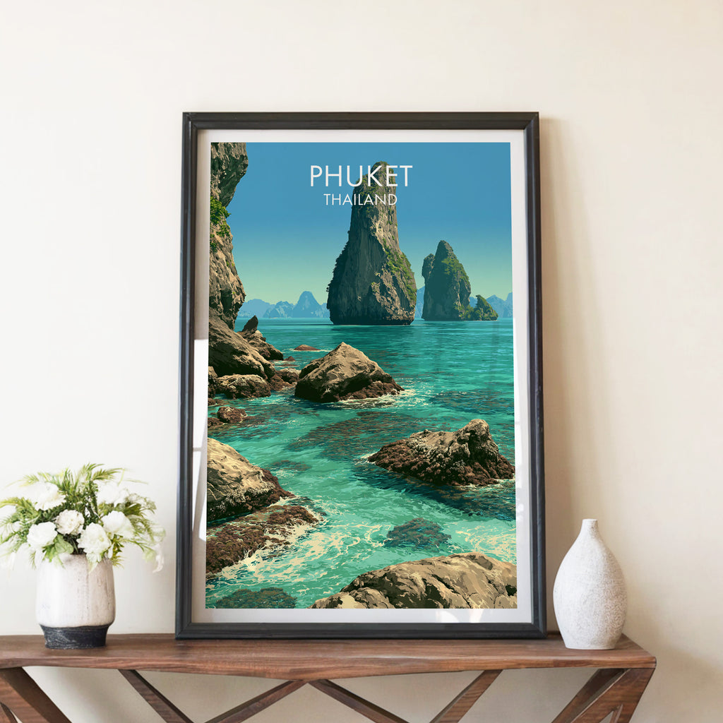 Phang Nga Bay Phuket Thailand travel poster in a black frame on a wooden console table with white flowers