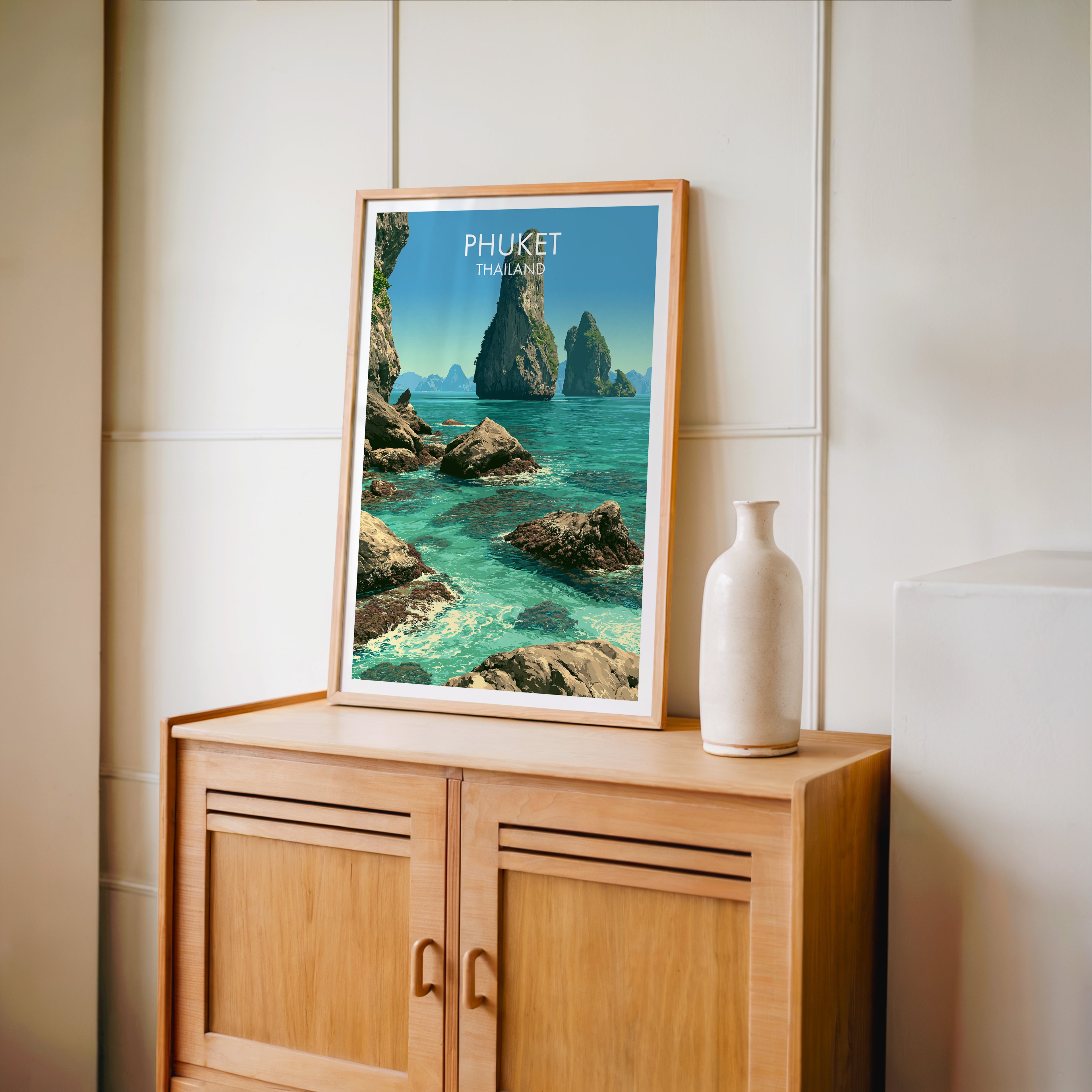 Small Phang Nga Bay Phuket Thailand travel poster in an oak frame on a mid-century sideboard with a ceramic vase