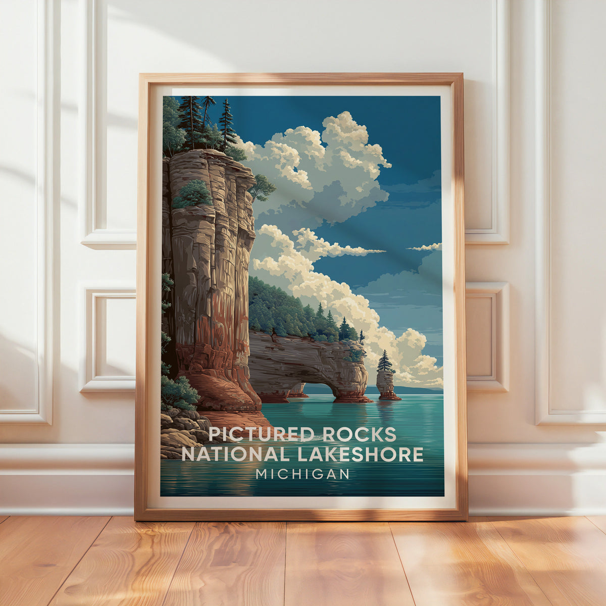 Pictured Rocks print in an oak frame by a panelled white wall with sunlight on the floor