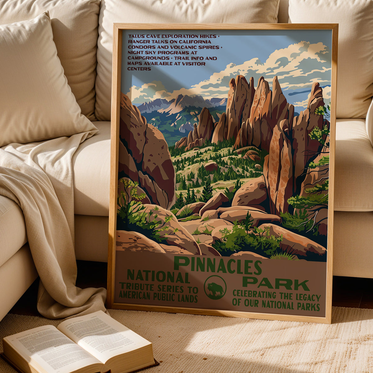 Pinnacles National Park WPA print leaning behind a cream sofa above an open book
