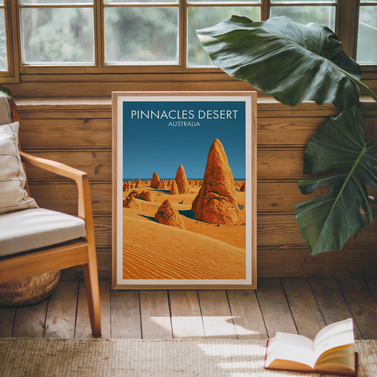 Desert spires poster in an oak frame against a pine cabin wall with a wooden armchair and open book