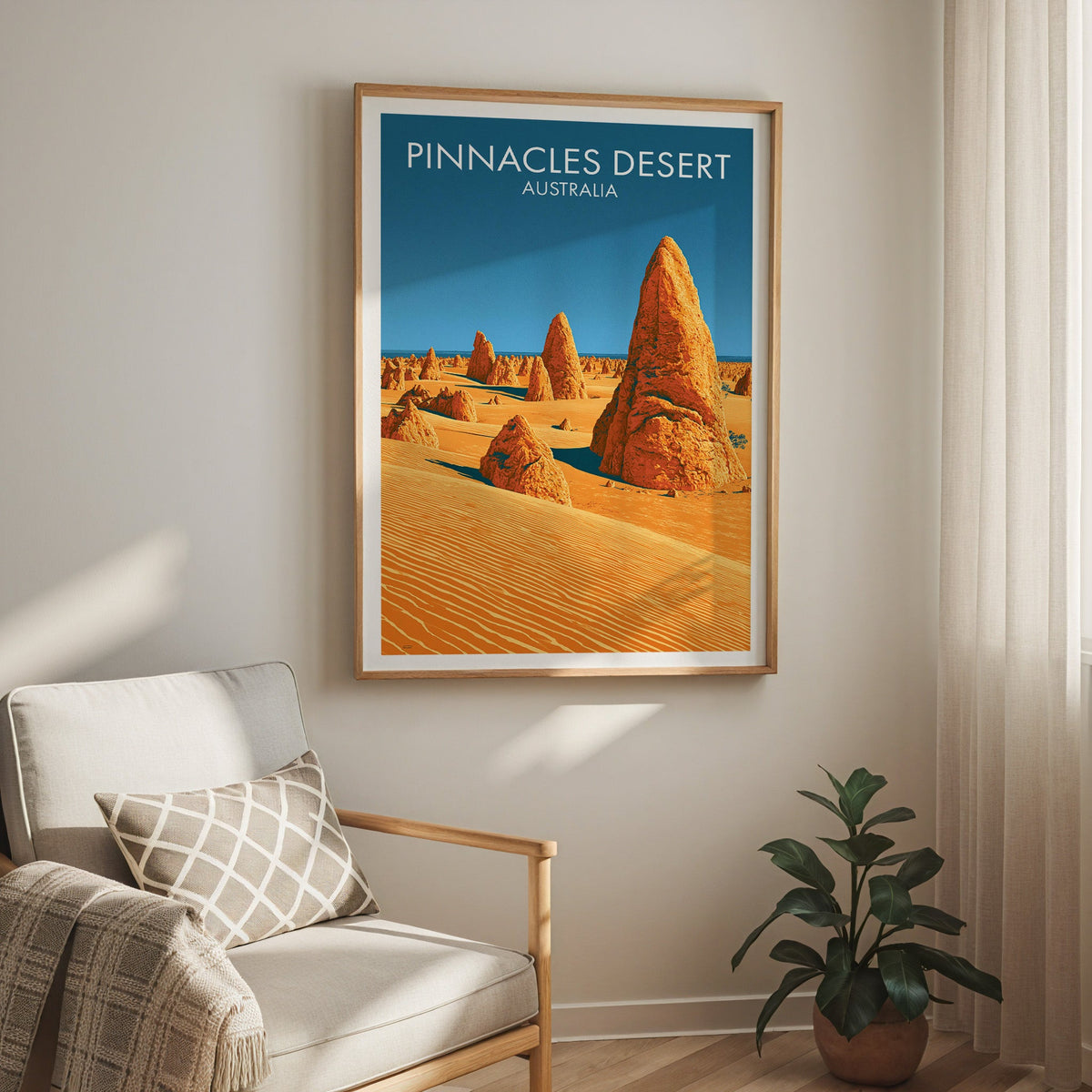 Warm desert print hung above a cream armchair with a lattice cushion, sheer curtain and rubber plant