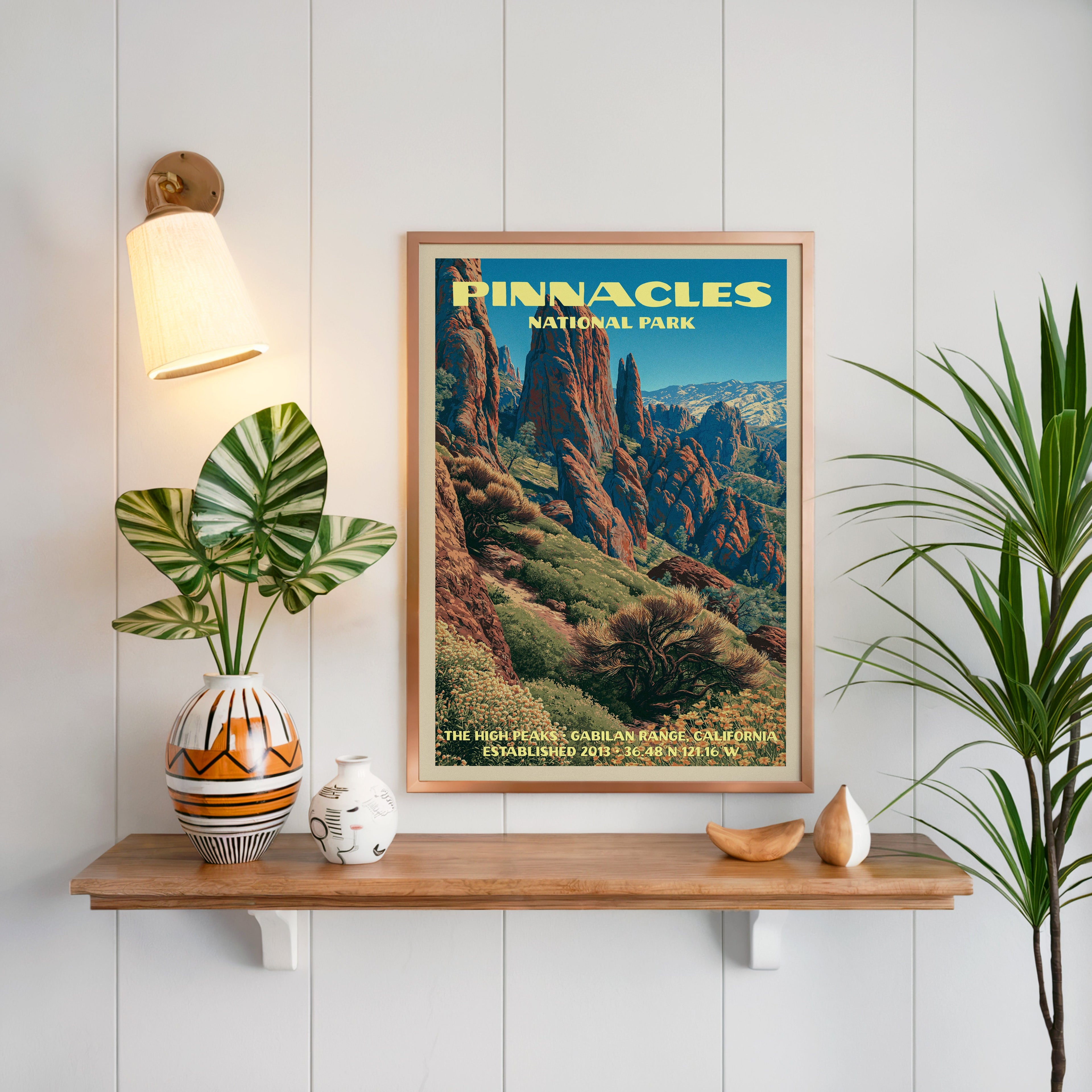 High Peaks Pinnacles print framed on white panelling above an oak shelf with a patterned vase and brass sconce