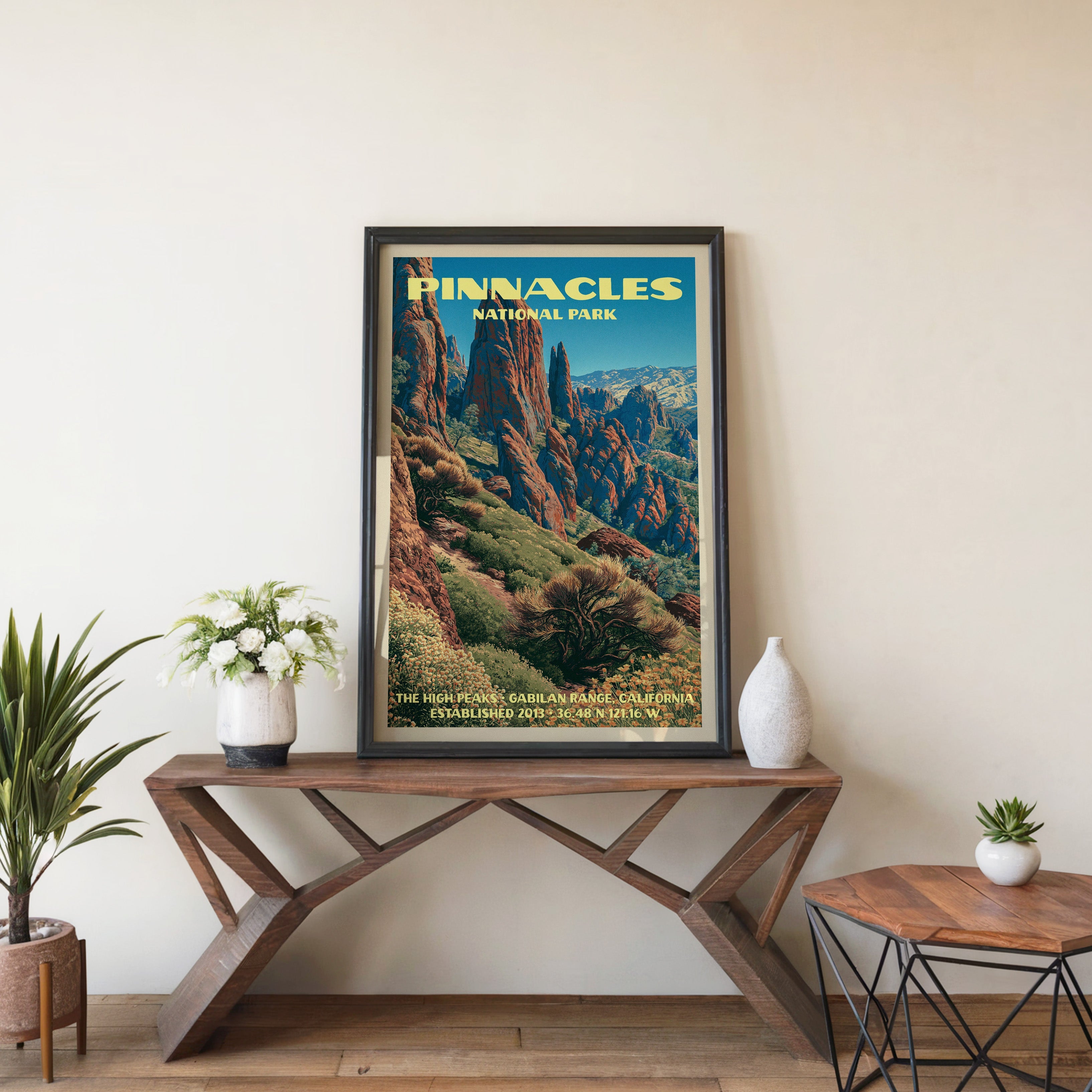Pinnacles High Peaks wall art in black, leaning on a walnut console with white anemones and a vase