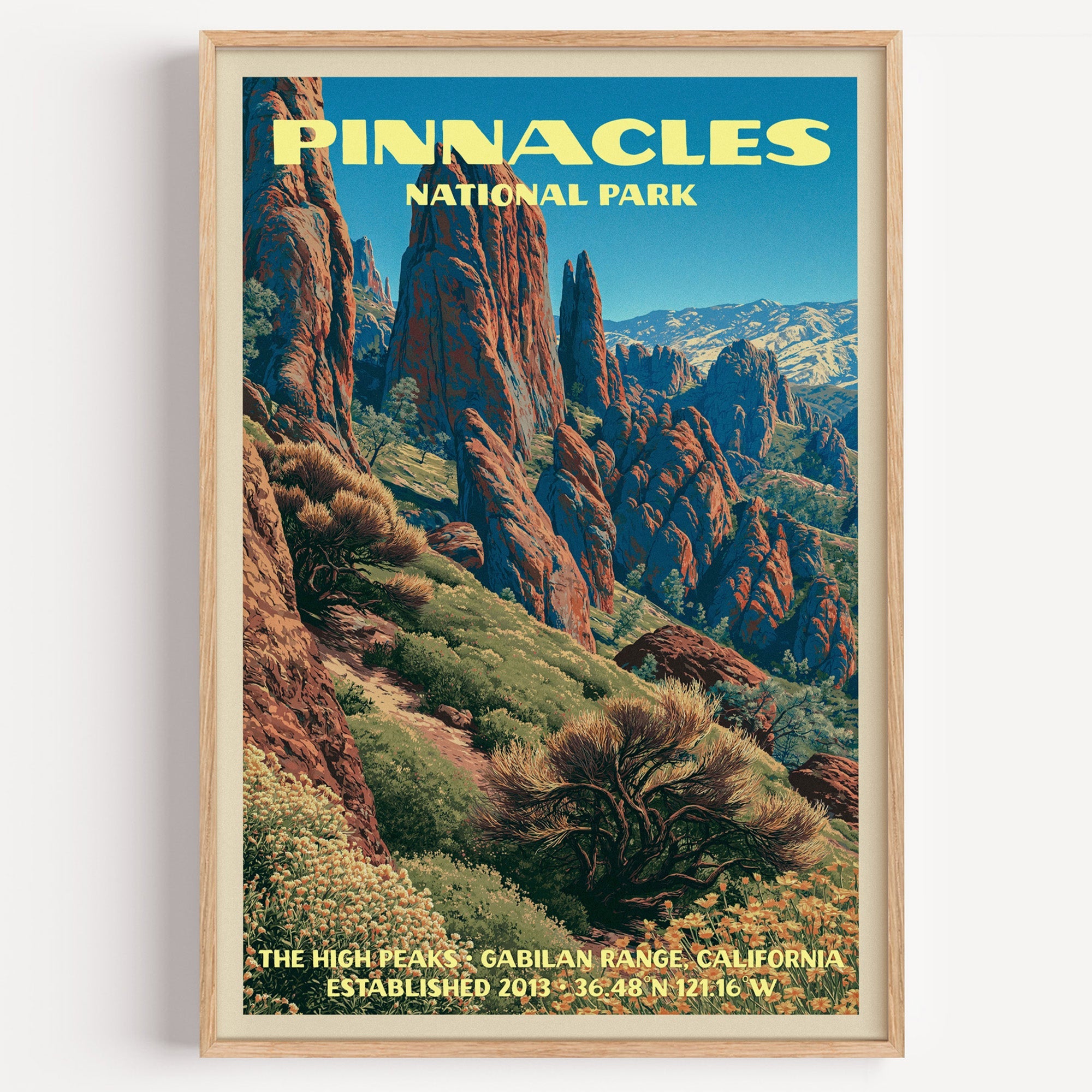 High Peaks Pinnacles National Park vintage poster in a light oak frame on a plain white wall