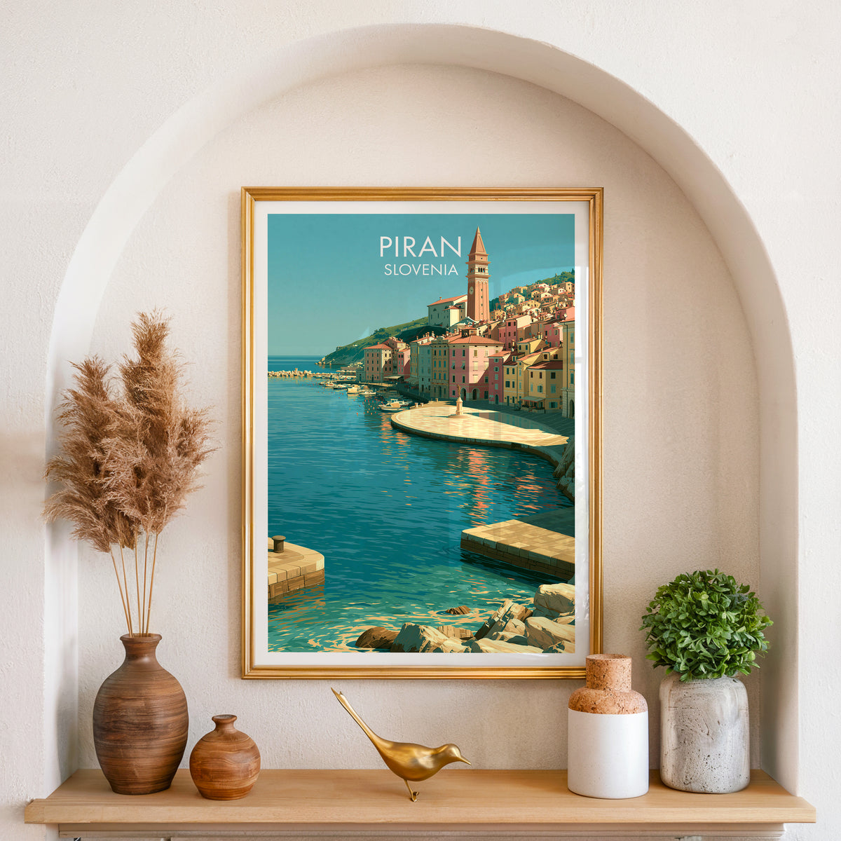 Piran Adriatic town poster, gold frame in an arched wall niche above pampas grass in a clay vase