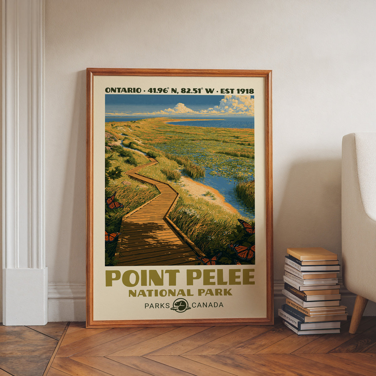 Point Pelee monarch marsh wall art in a walnut frame on a herringbone floor beside stacked books