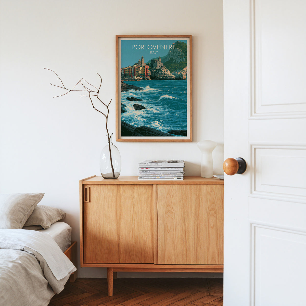 Portovenere church headland print, oak frame above a light oak sideboard with bare branches in a glass vase