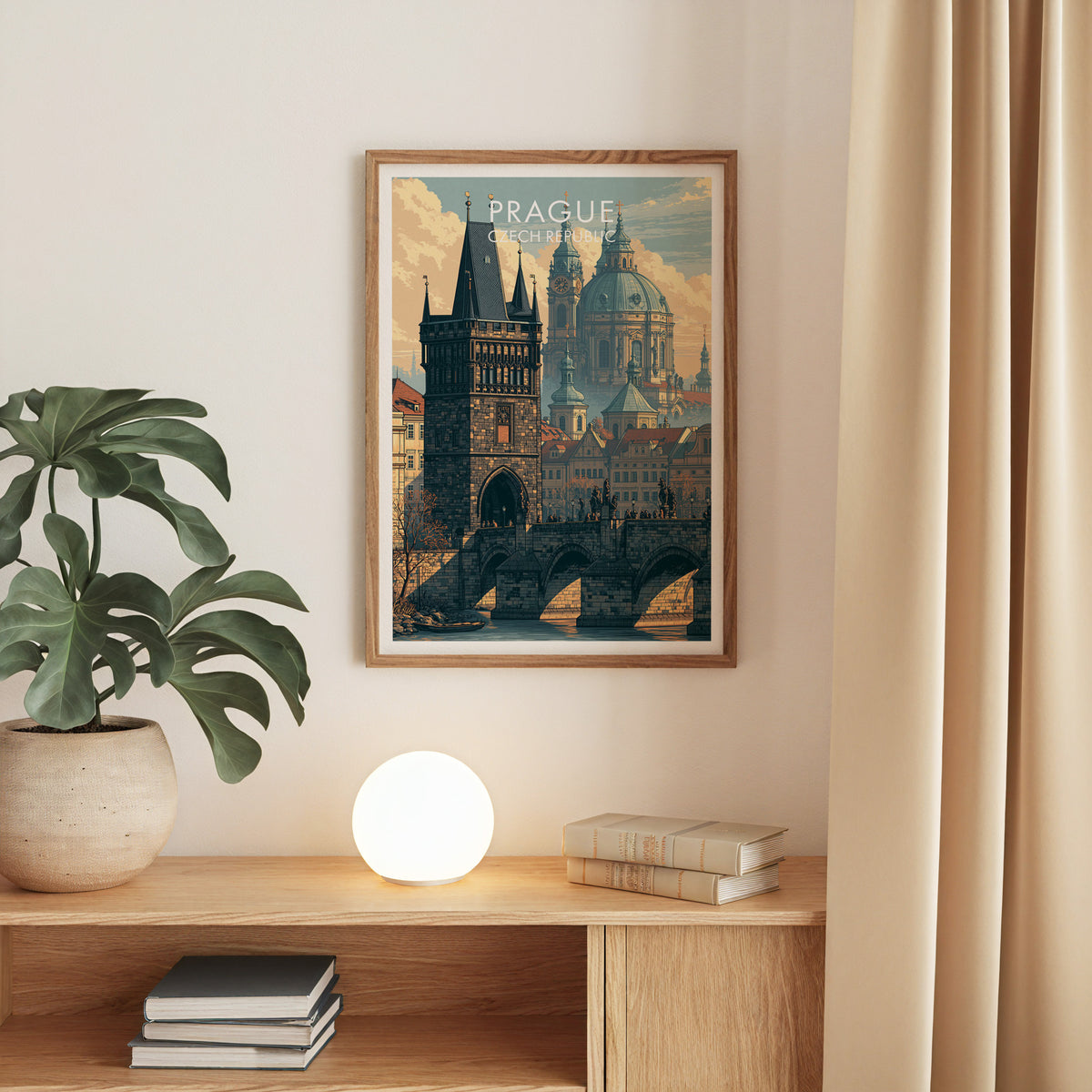 Prague Charles Bridge poster in oak above an oak console with a monstera, a globe lamp and books