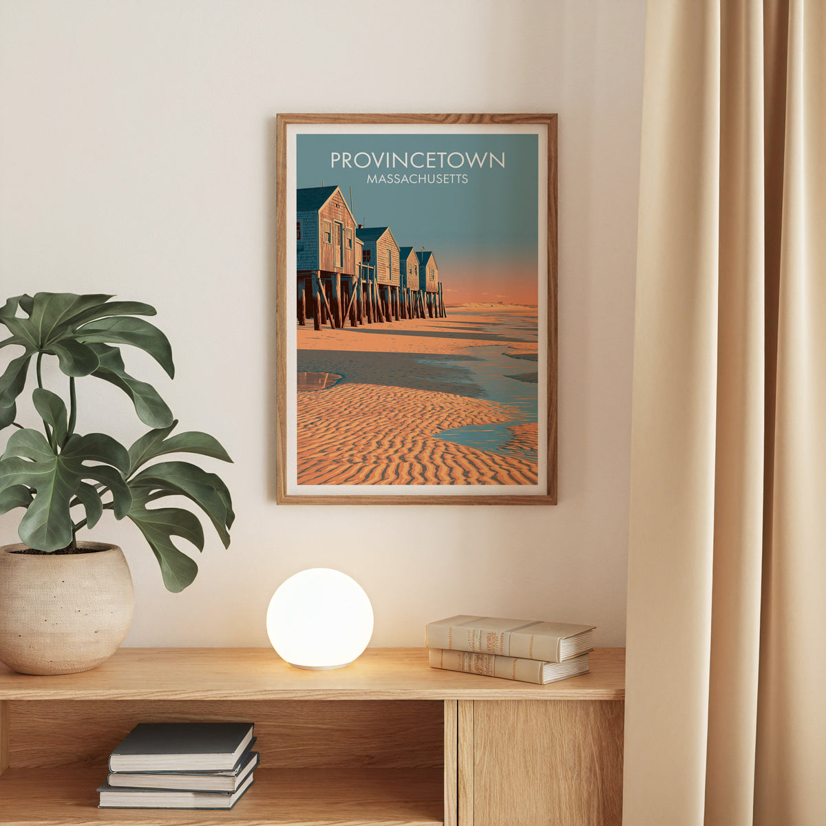 Provincetown Cape Cod art print in an oak frame on a beige wall above an oak console and monstera