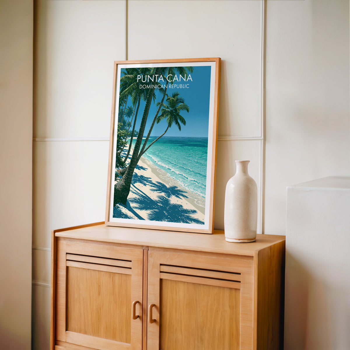 Striped palm shadows in an oak frame standing on a light oak cabinet against a cream panelled wall
