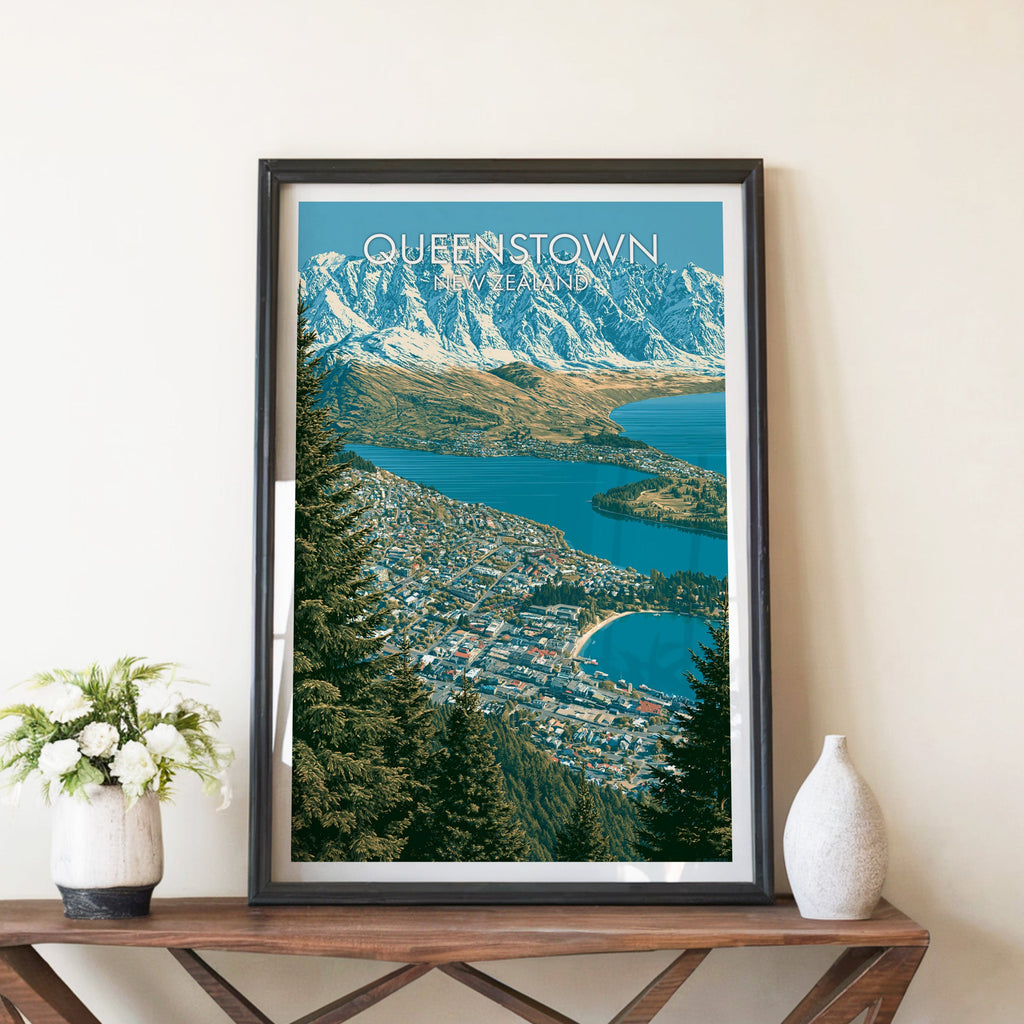 Queenstown poster in a black frame on a walnut console with white peonies and a tall stone vase