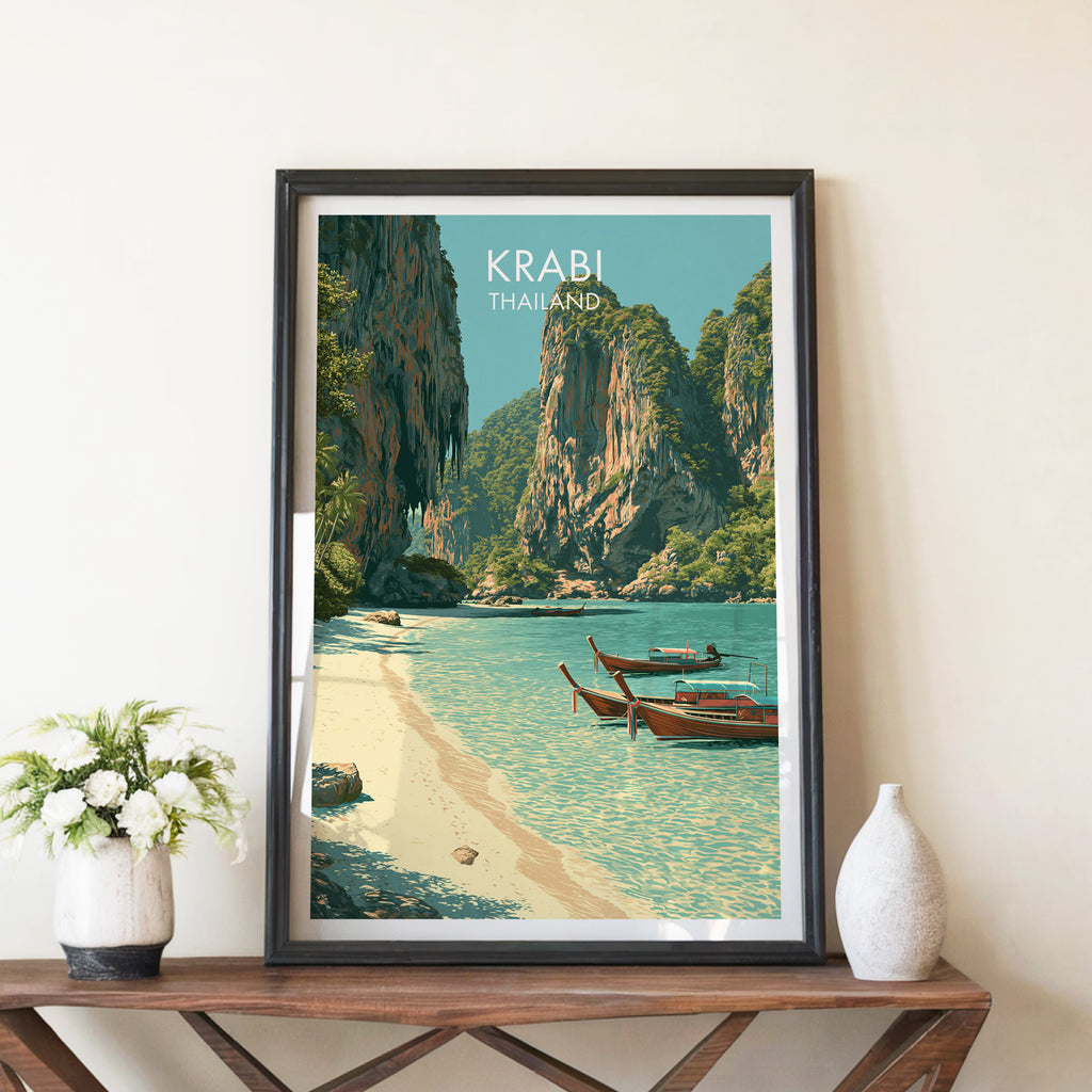 Railay Beach Krabi Thailand travel poster in a black frame on a wooden console table with white flowers