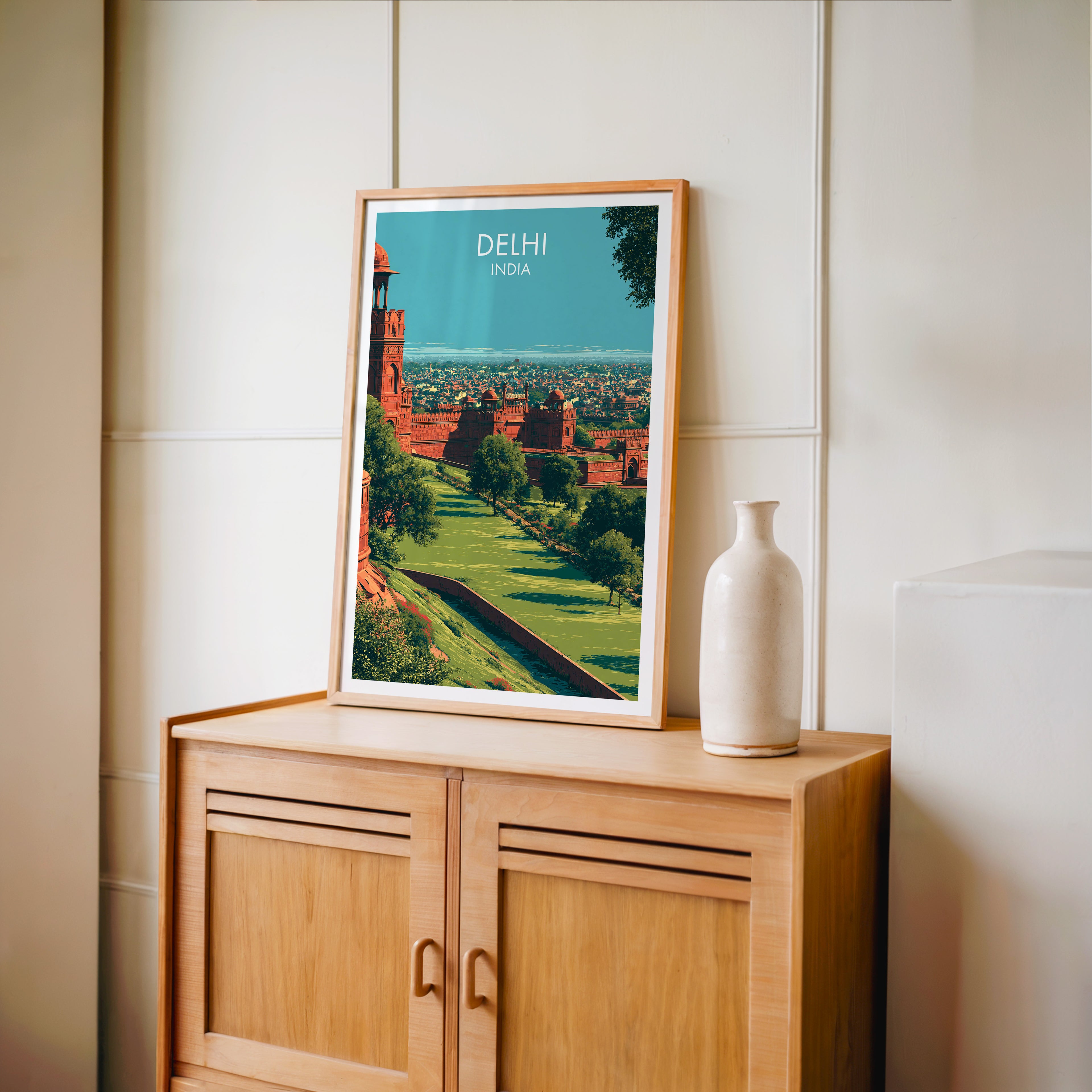 Small Red Fort Delhi India travel poster in an oak frame on a mid-century sideboard with a ceramic vase