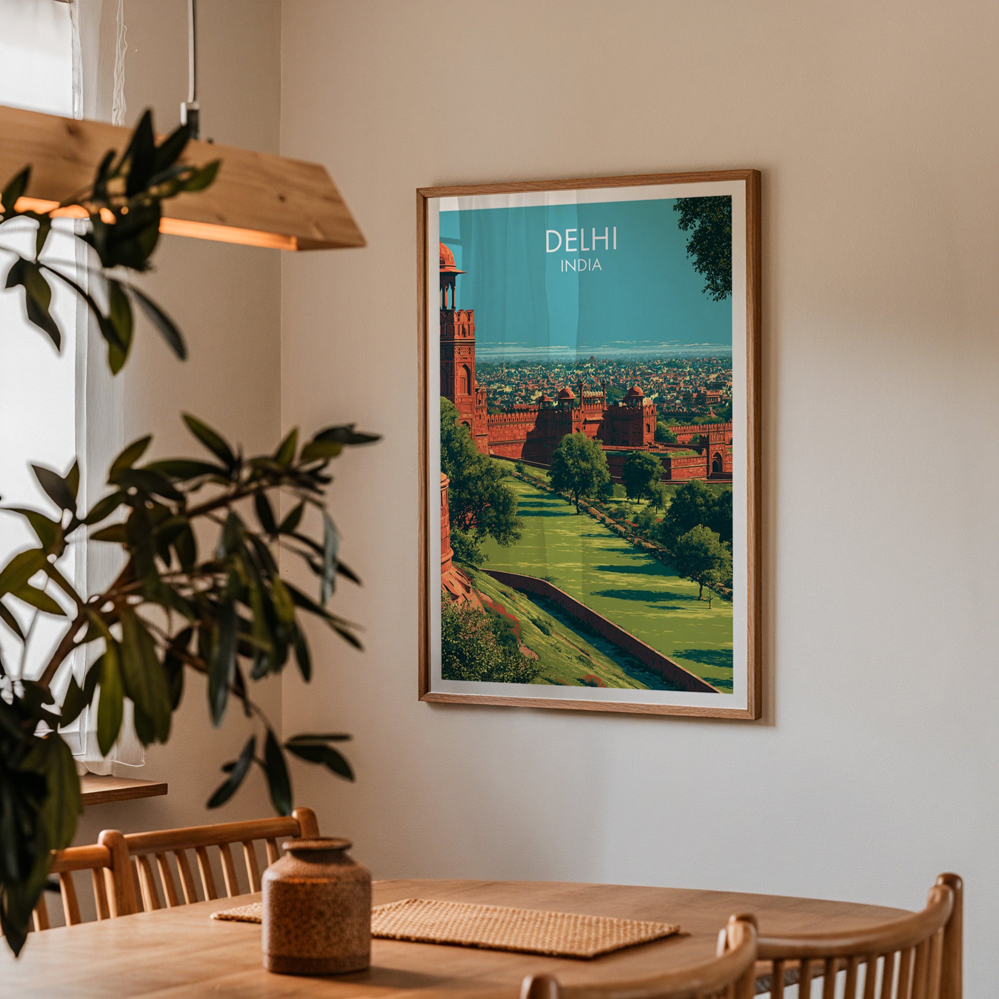Framed Red Fort Delhi India print on a dining room wall above an oak table in warm afternoon light