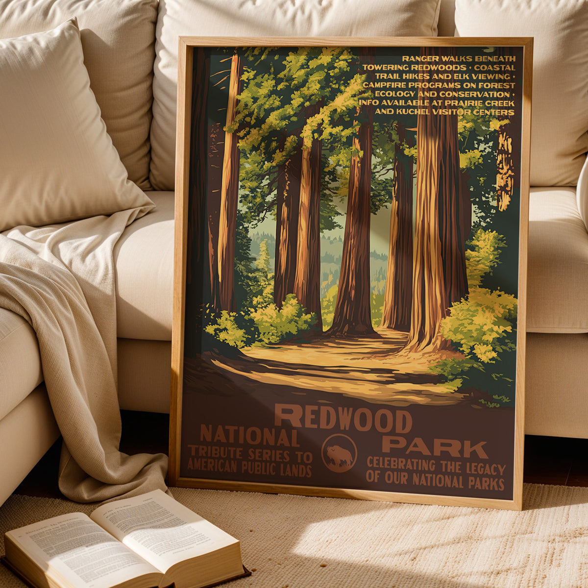 Redwood National Park WPA print leaning behind a cream sofa above an open book
