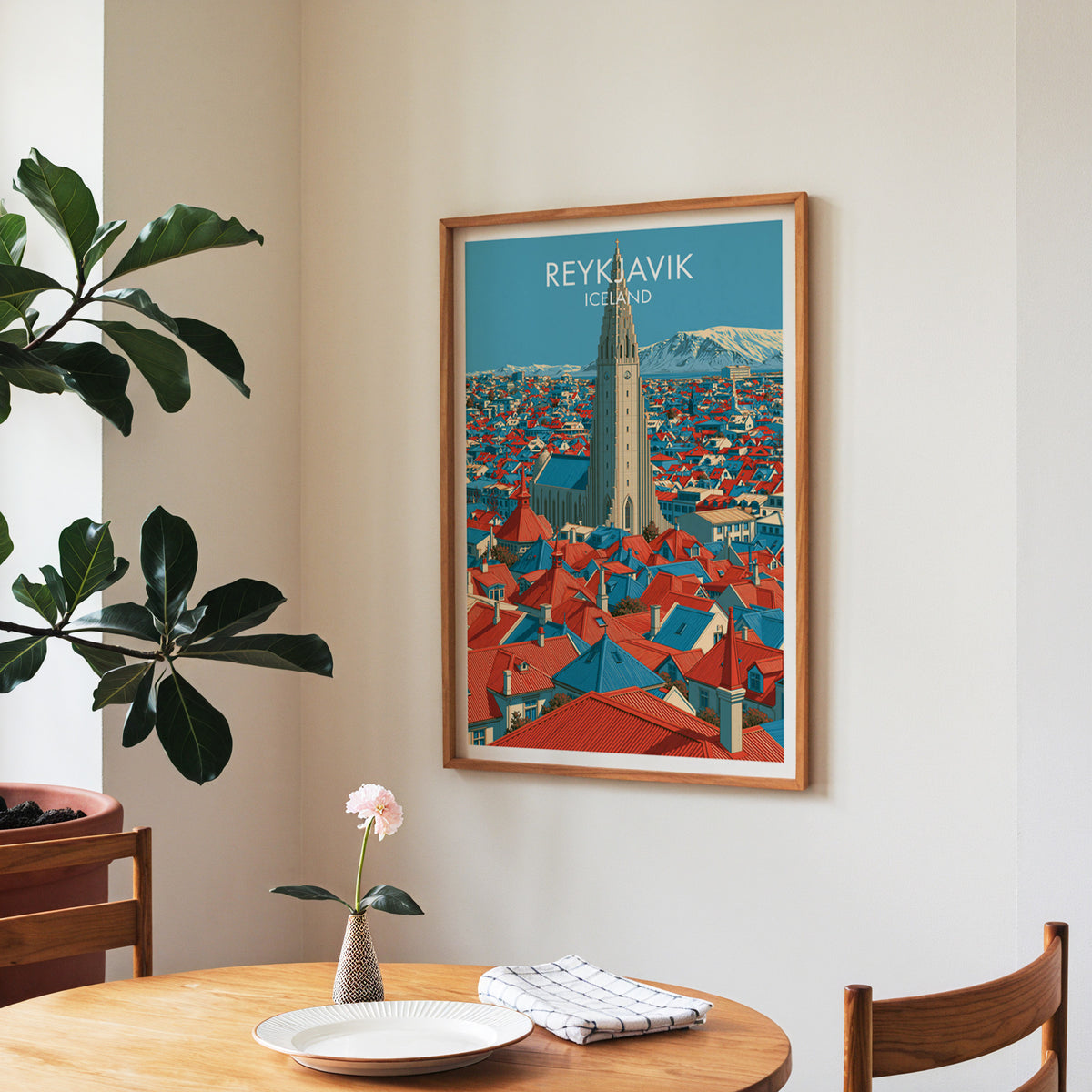 Reykjavik poster, walnut frame in a dining corner above a round table and a fiddle-leaf fig