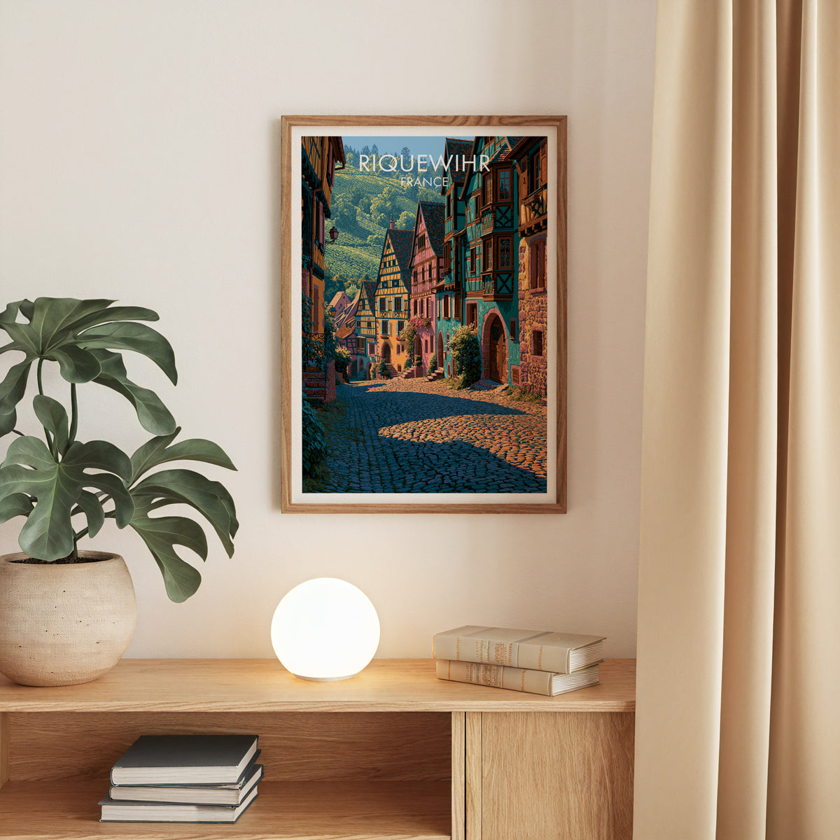 Riquewihr half-timbered print, oak frame above an oak console with a monstera and a round globe lamp