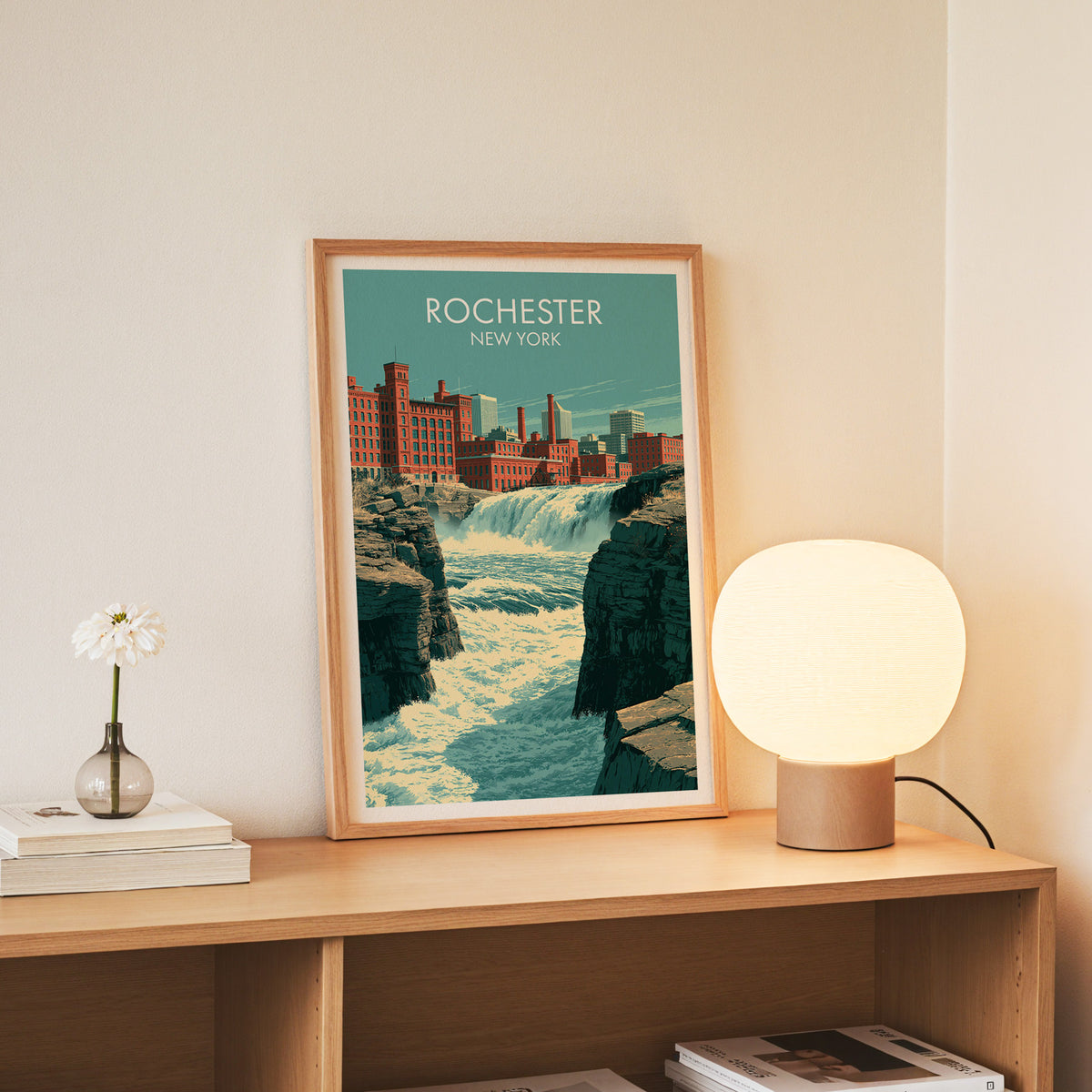 Rochester New York print in a slim oak frame standing on a console with daisies in a glass jar.