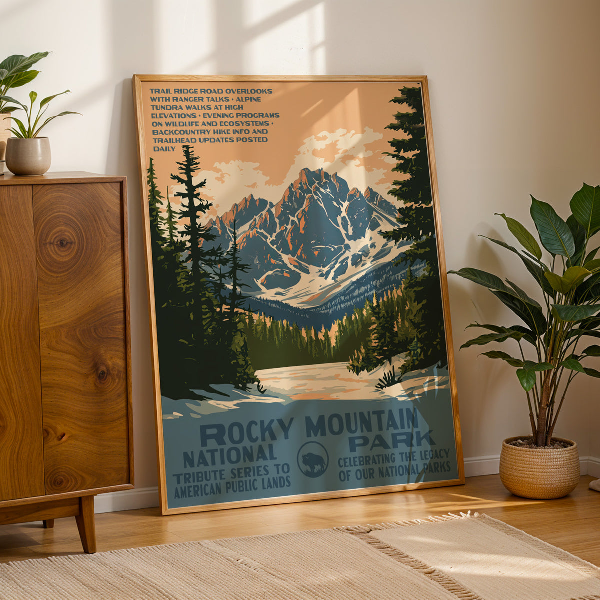 Rocky Mountain National Park WPA print framed on a wood floor beside a cabinet and potted plant