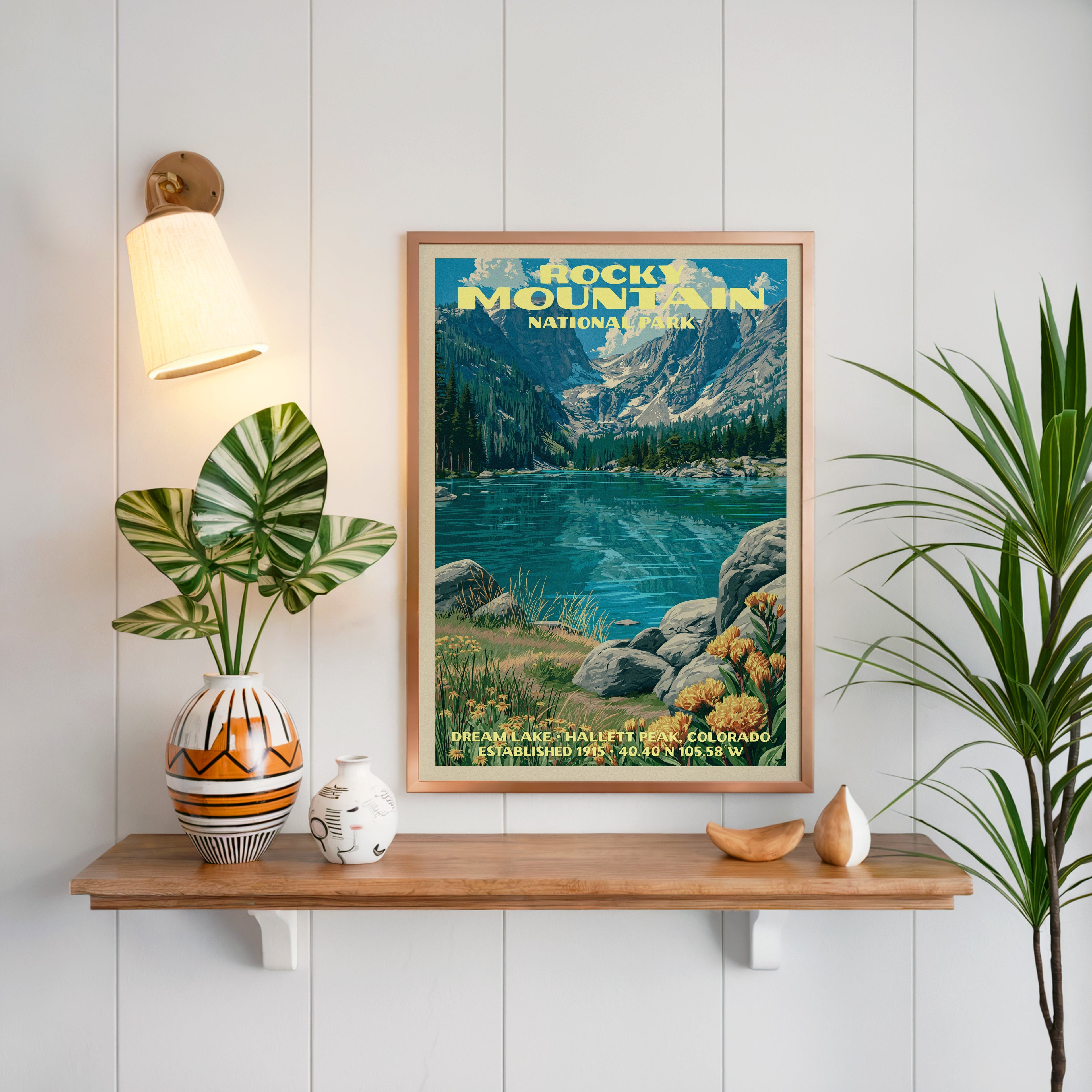 Rocky Mountain Dream Lake print framed on white panelling above an oak shelf with a patterned vase