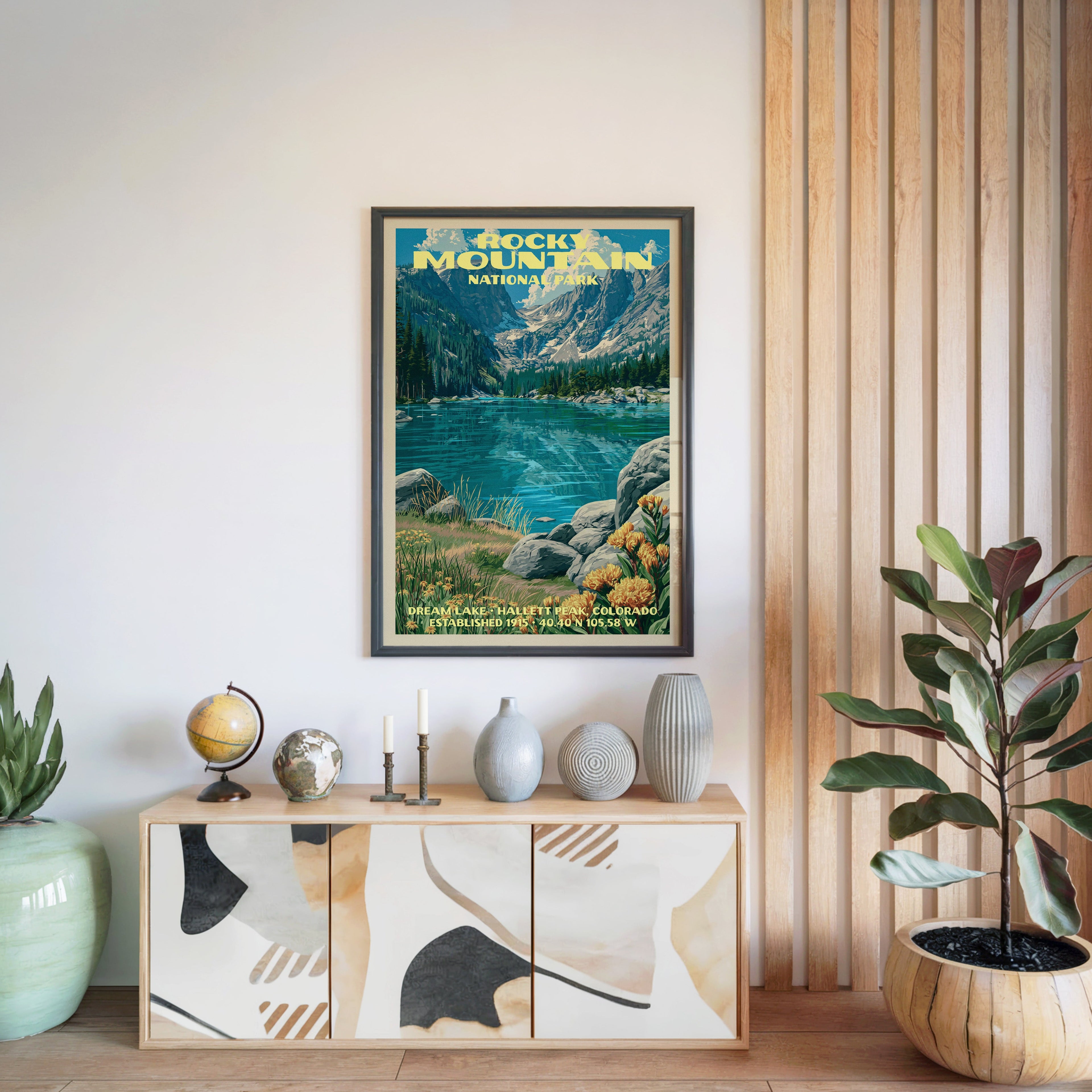 Rocky Mountain National Park print in a black frame above a light wood sideboard by a slatted wall panel