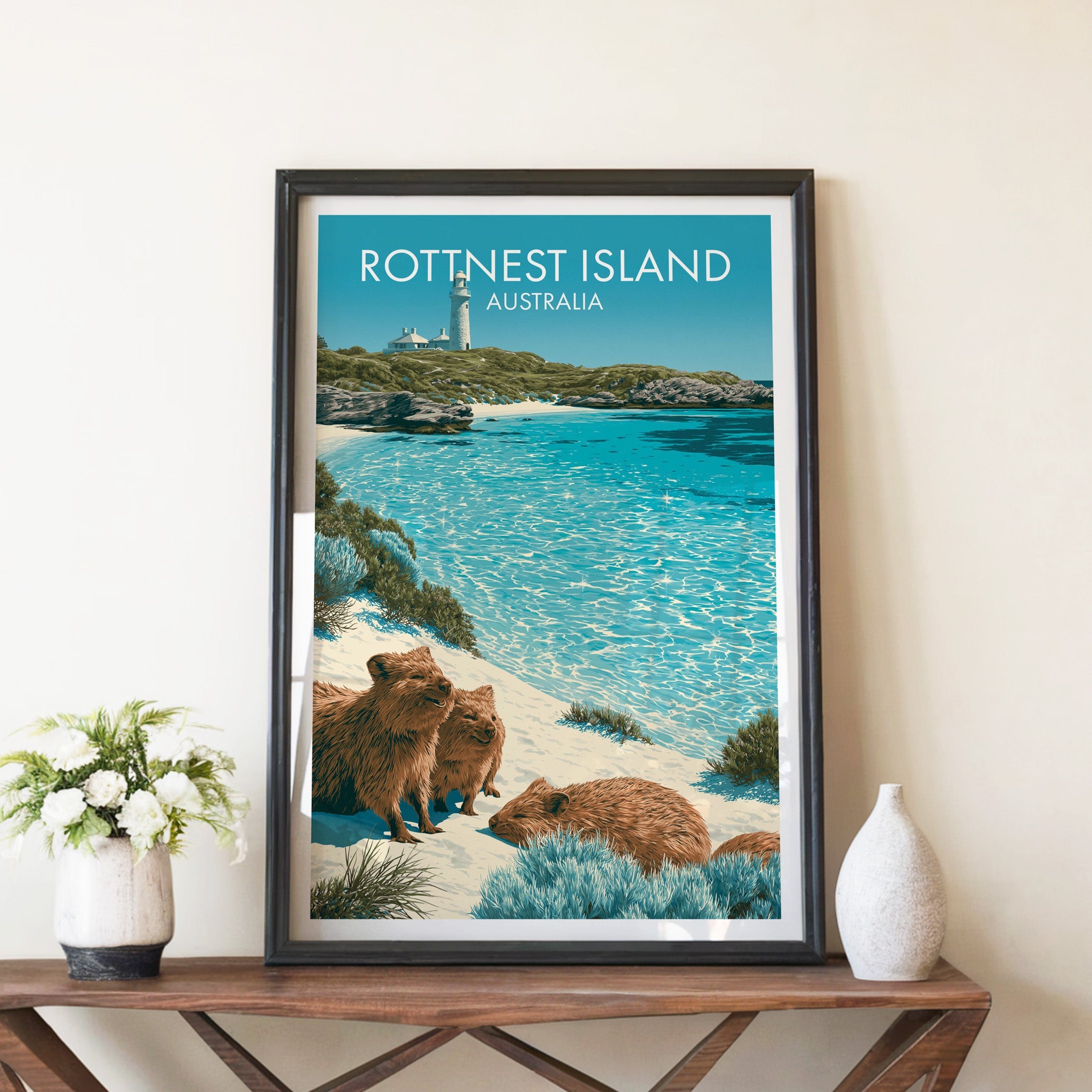 Quokka beach print in a black frame on a walnut console with white peonies and a tall ceramic vase