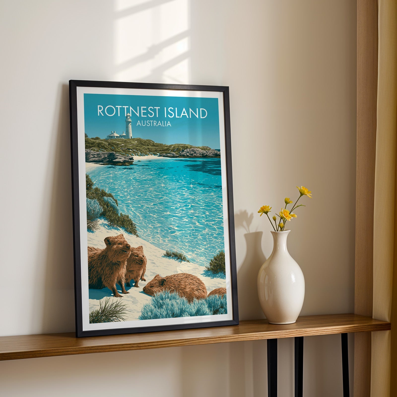 Turquoise island bay artwork in a black frame on a wood shelf with yellow daisies on a sunlit cream wall
