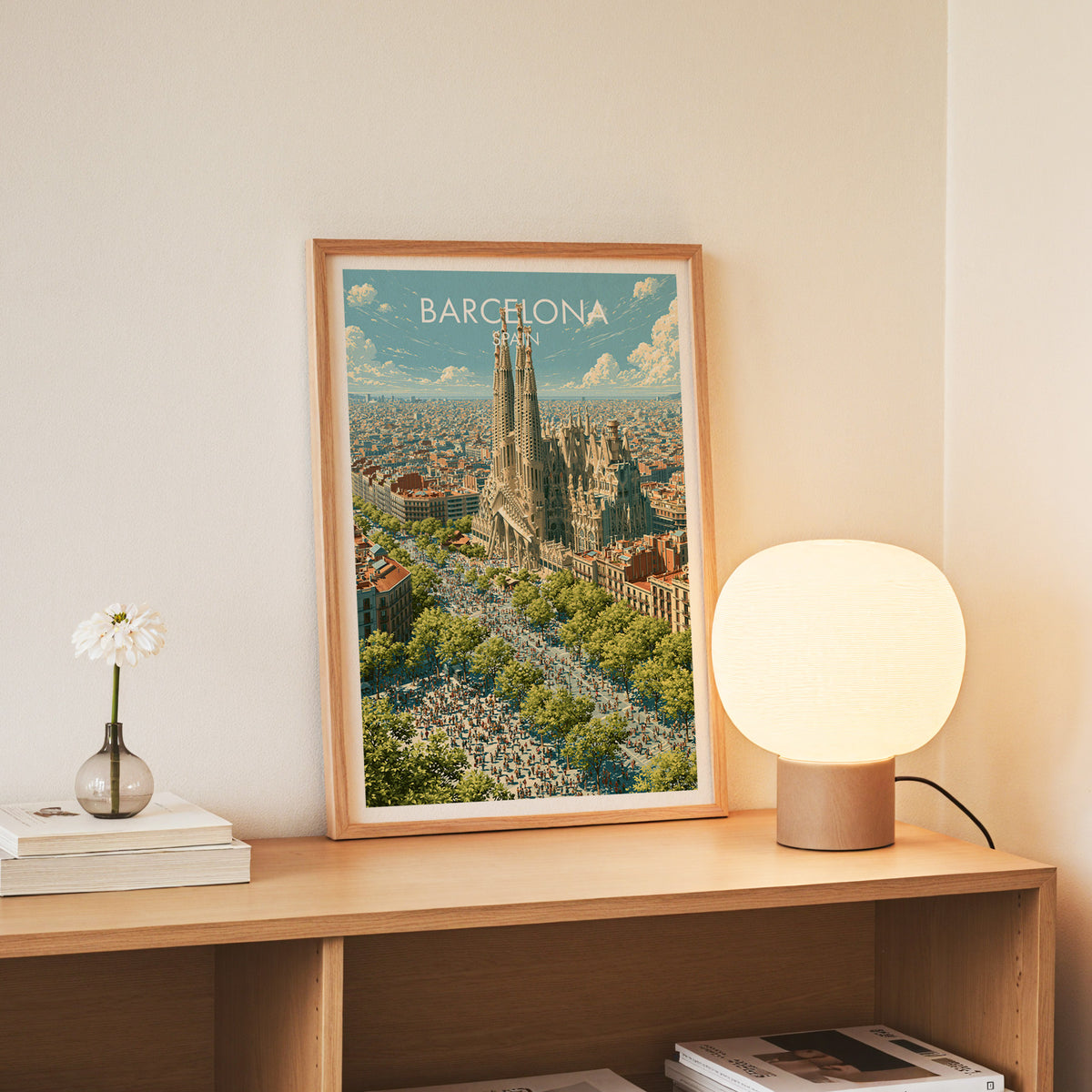 Barcelona skyline poster, slim oak frame standing on an oak console beside a daisy in a glass bottle