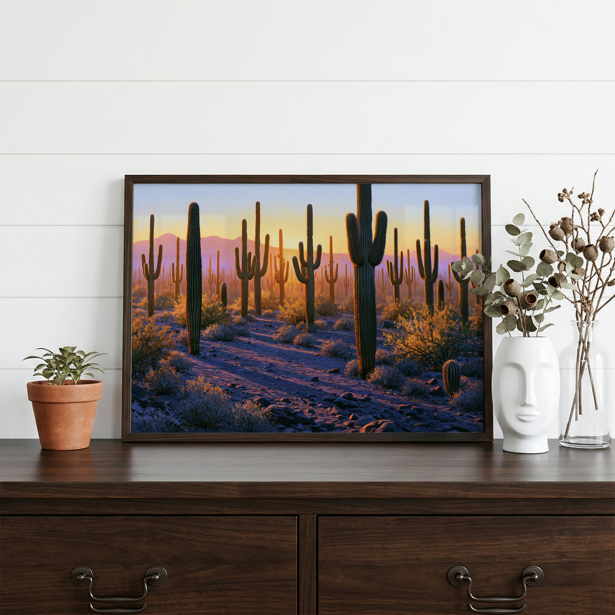 Saguaro classical oil painting in a walnut frame resting on a dark wood dresser