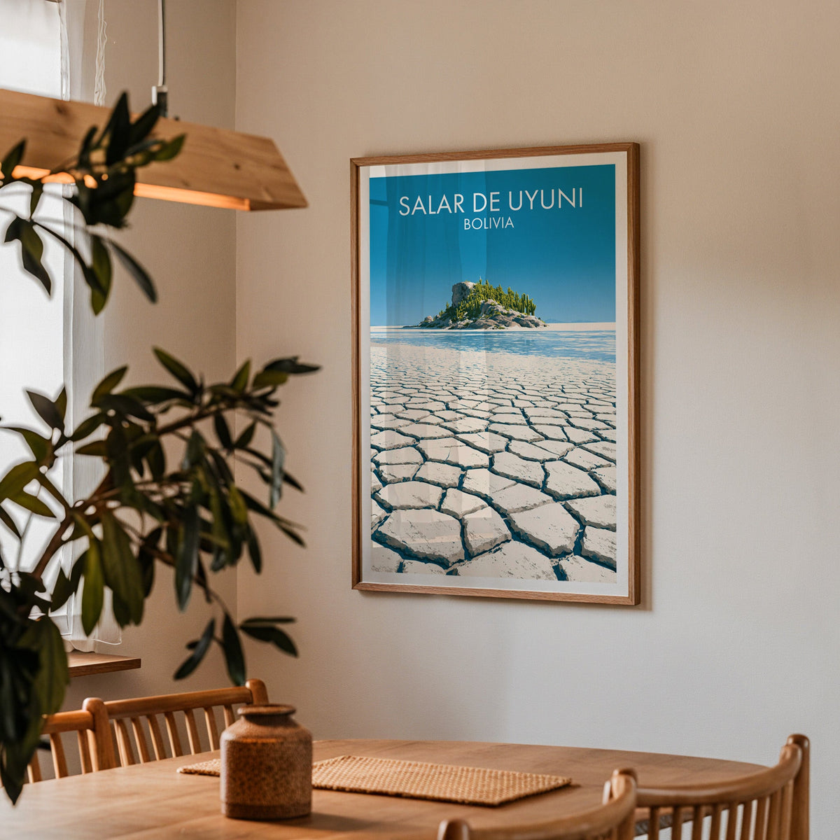 Salt flat travel art in an oak frame in a dining corner with a wood table, cane chairs and an olive branch