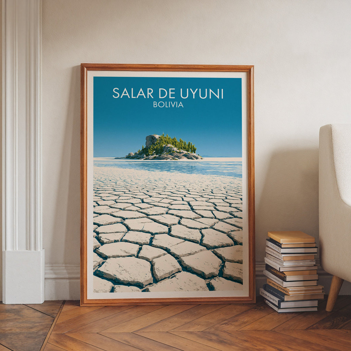Uyuni salt flat print in a walnut frame on a herringbone floor by white wall moulding, book stacks and an armchair