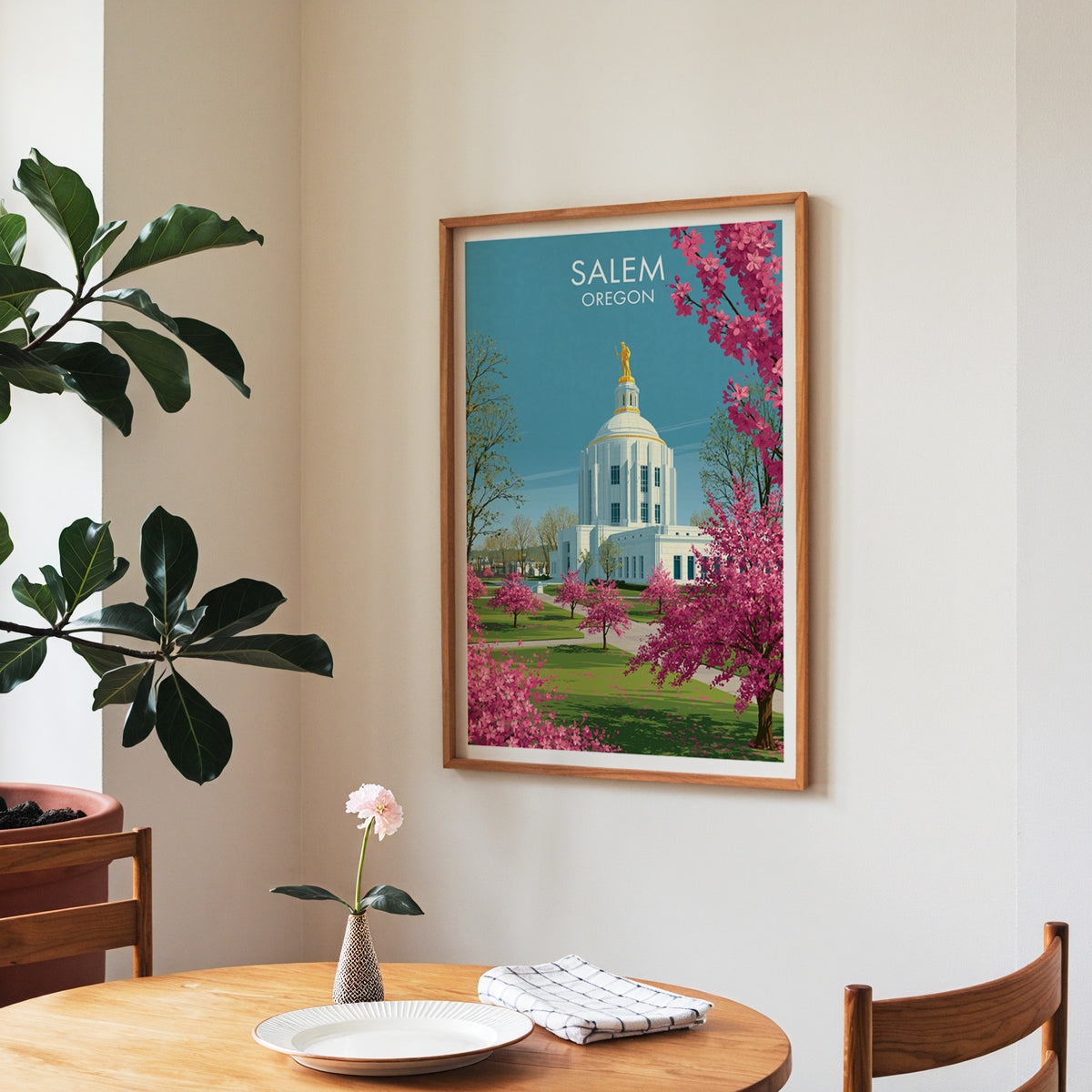 Salem Oregon artwork in a walnut frame in a dining nook with a round table, plates and roses.