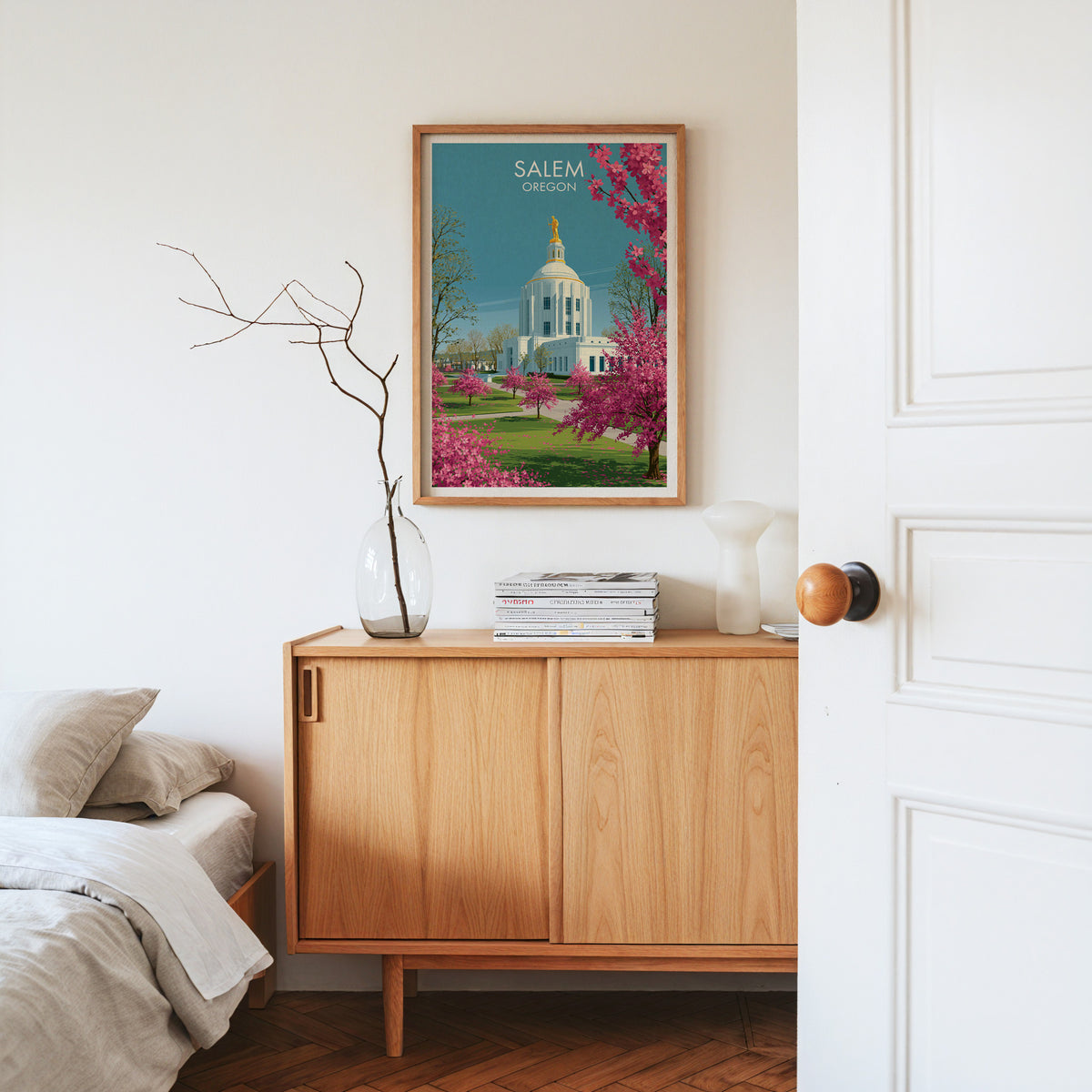 Cherry blossom capitol print in oak on a light oak sideboard with dried branches in a glass vase.