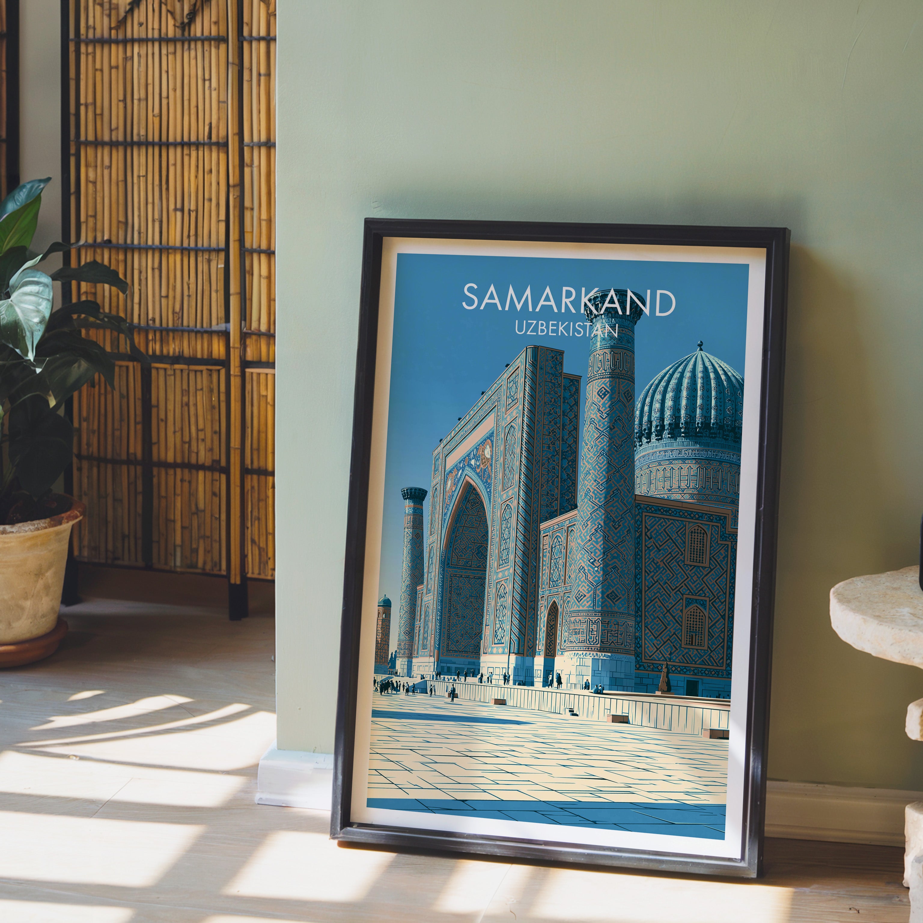 Samarkand Uzbekistan wall art in a black frame leaning against a sage green wall beside a bamboo screen