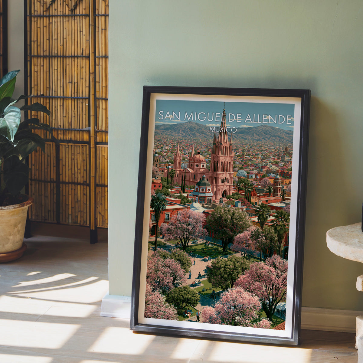 Pink and sage town view, black frame leaning on pale wood floor by a sage wall and bamboo screen