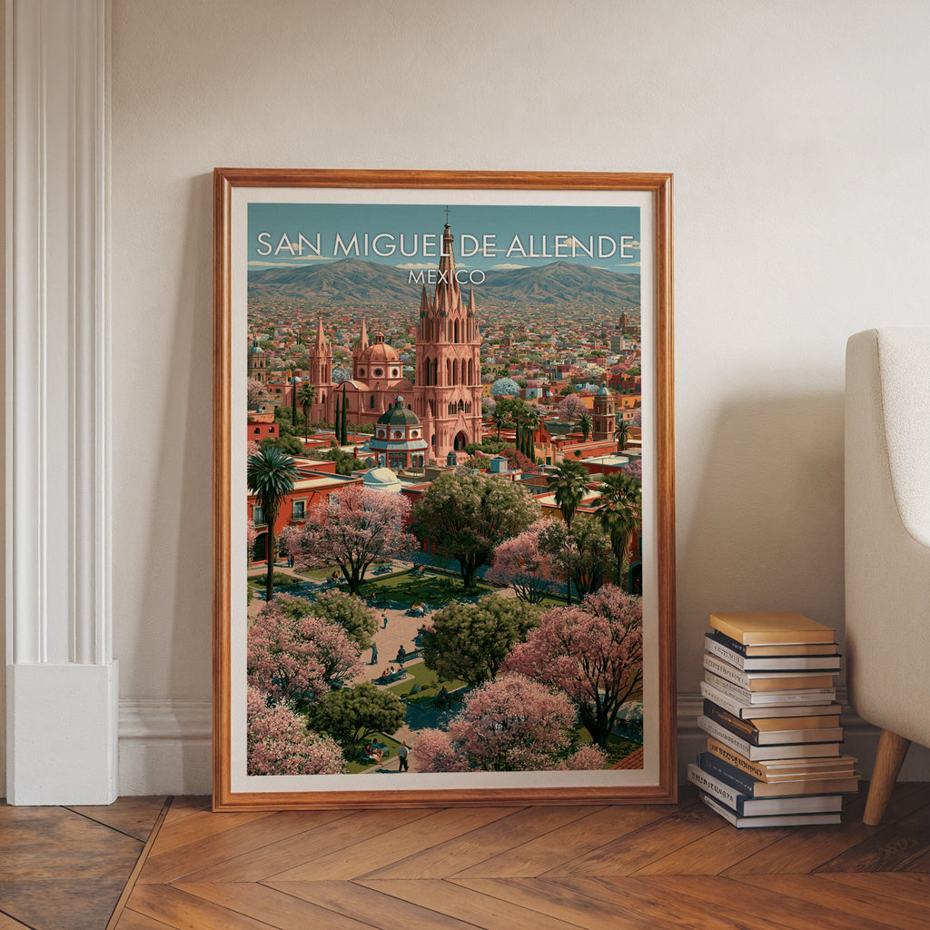 Pink spire poster in a walnut frame on a herringbone floor with stacked books and a pale armchair