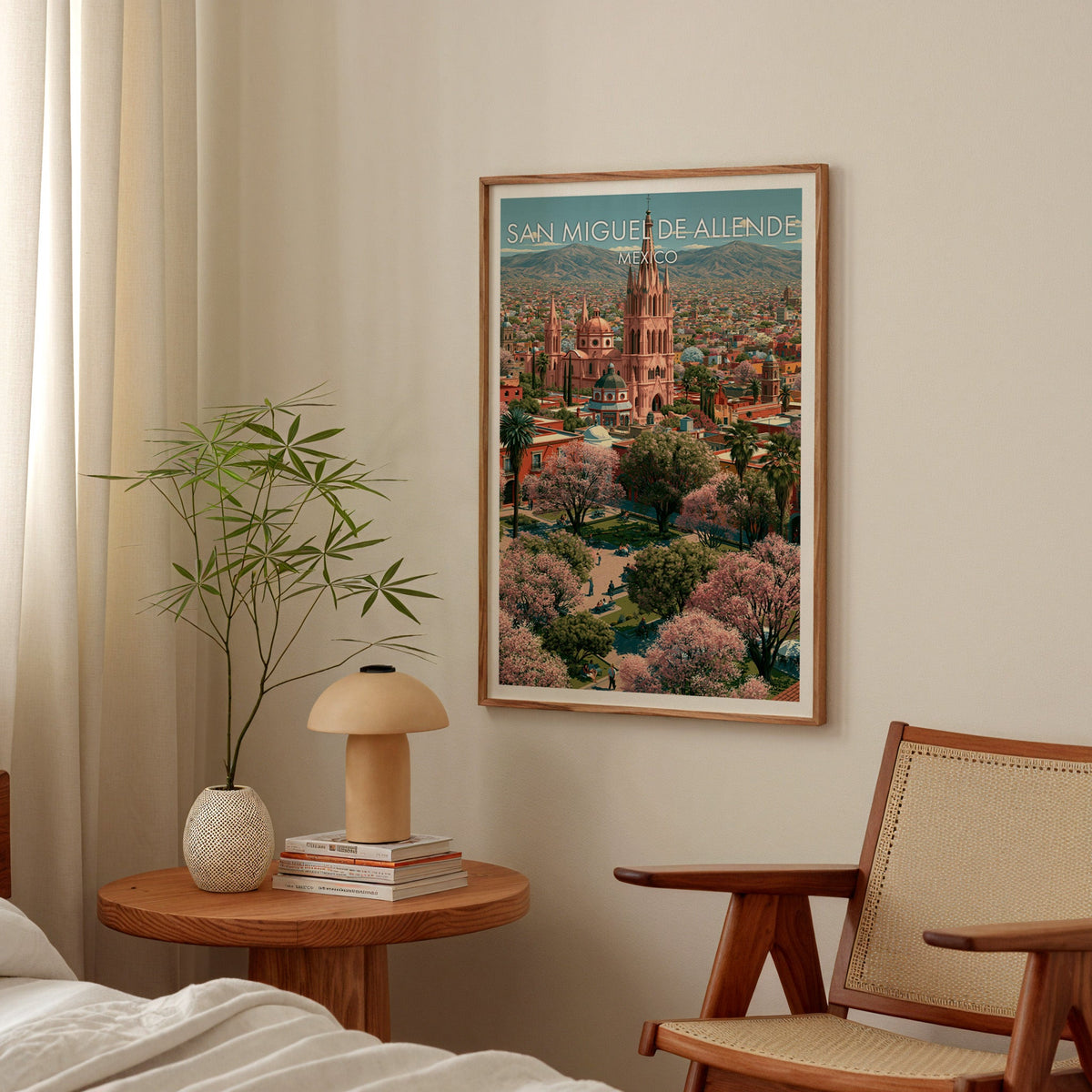 Soft rose and olive scene in an oak frame above a round bedside table with a mushroom lamp and bamboo