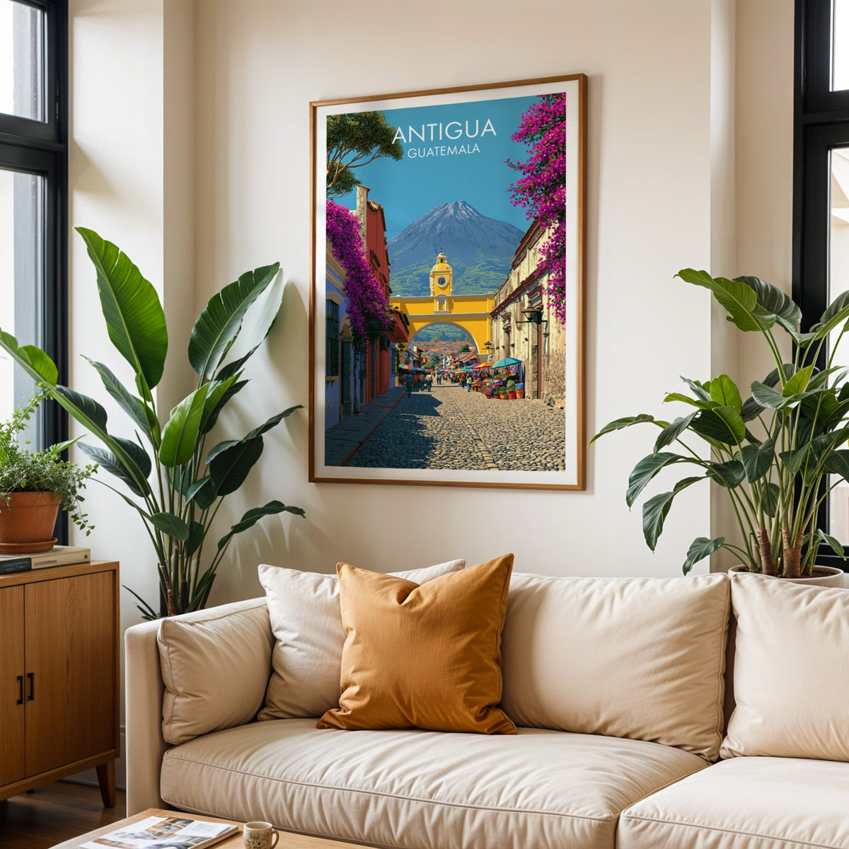 Magenta blossom and blue facades in an oak frame above a cream sofa, burnt-orange cushion and tropical plants