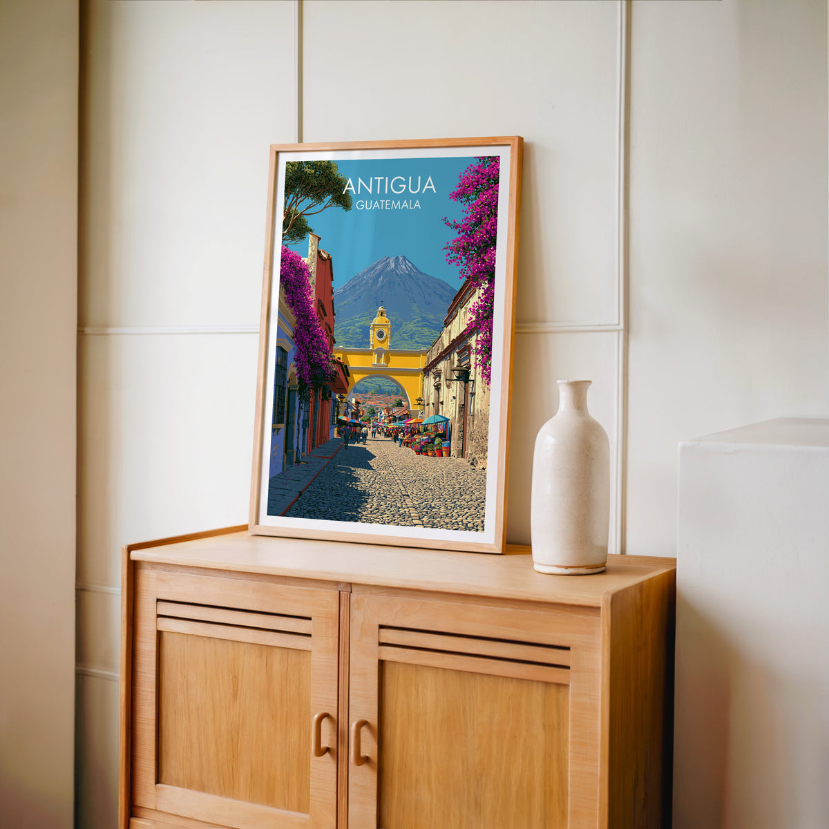 Antigua street market awnings in an oak frame on a light oak cabinet, cream panelled wall and pale bottle vase